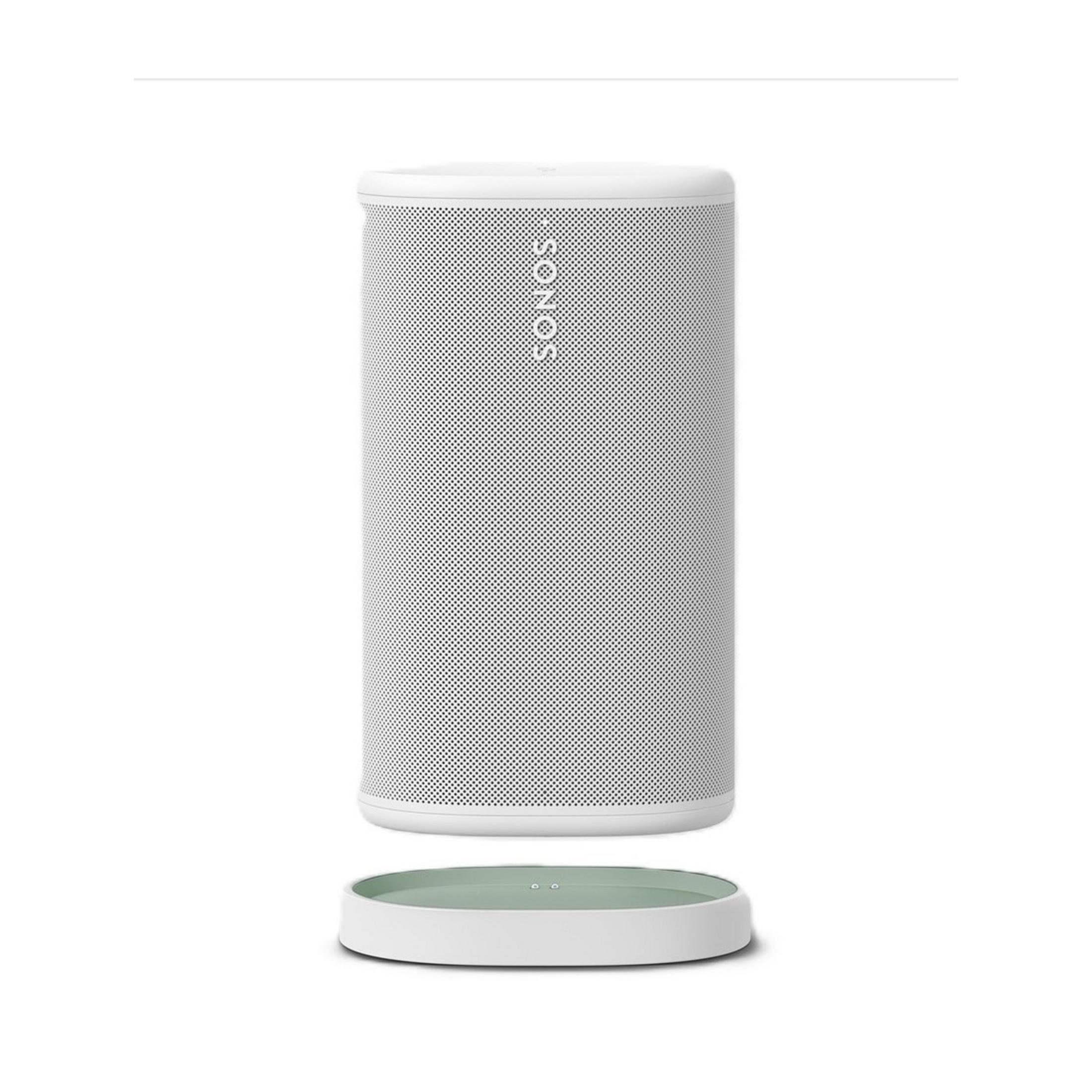 Ein weißer Sonos-Lautsprecher steht auf einer weißen Ladestation mit grünem Innenleben.