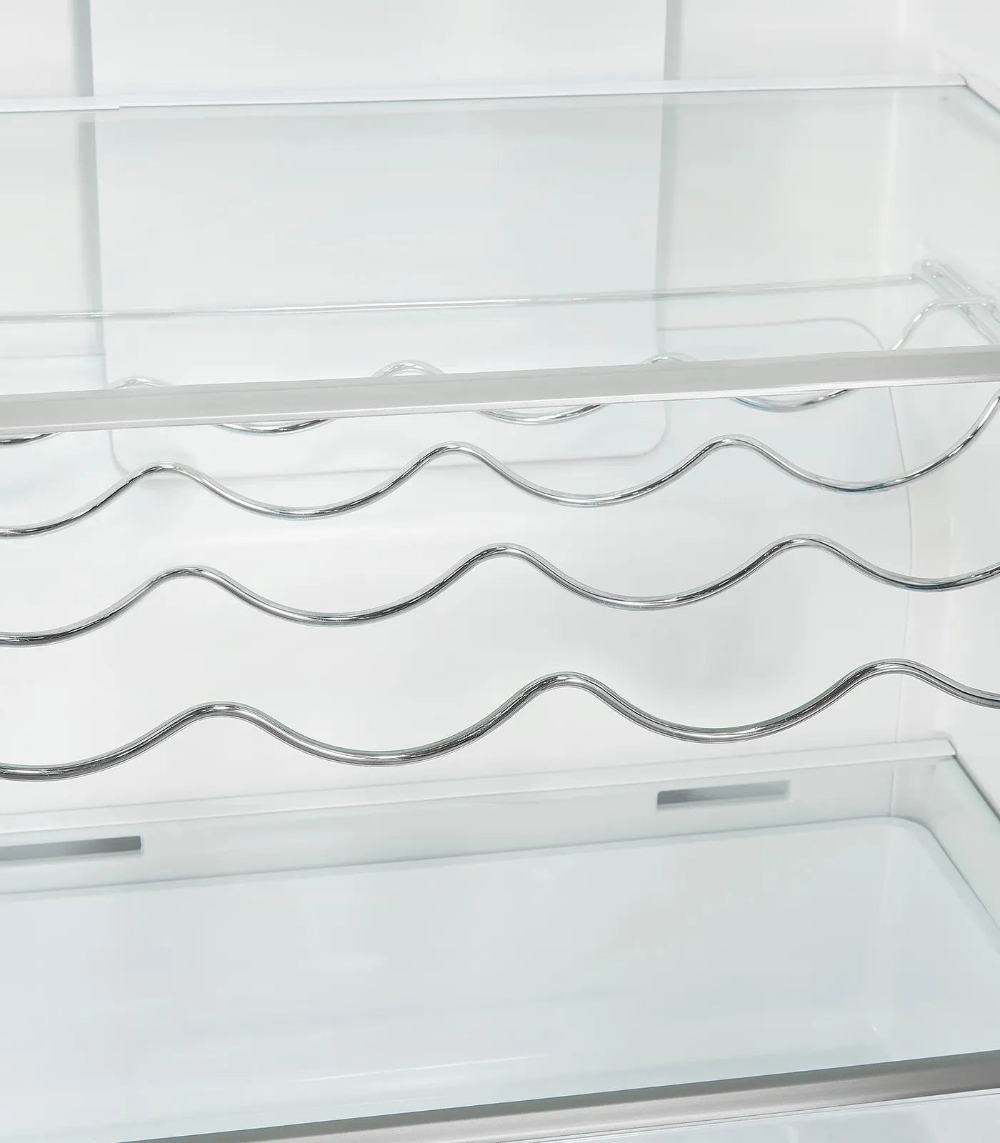 Kühlschrankinnenraum mit Glasböden und einem Chrom-Weinregal.