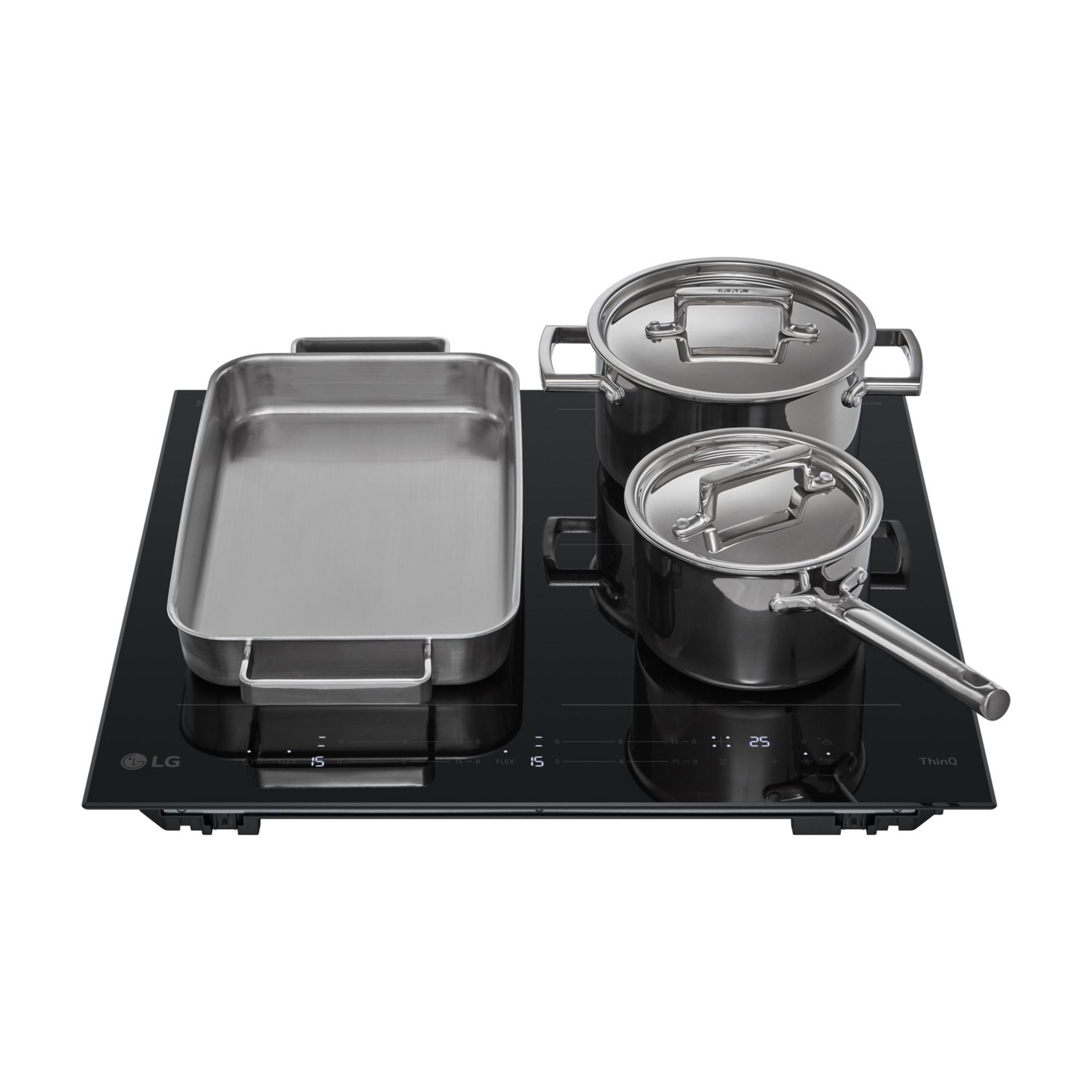 An induction cooktop with three pieces of cookware: a roasting pan and two pots.
