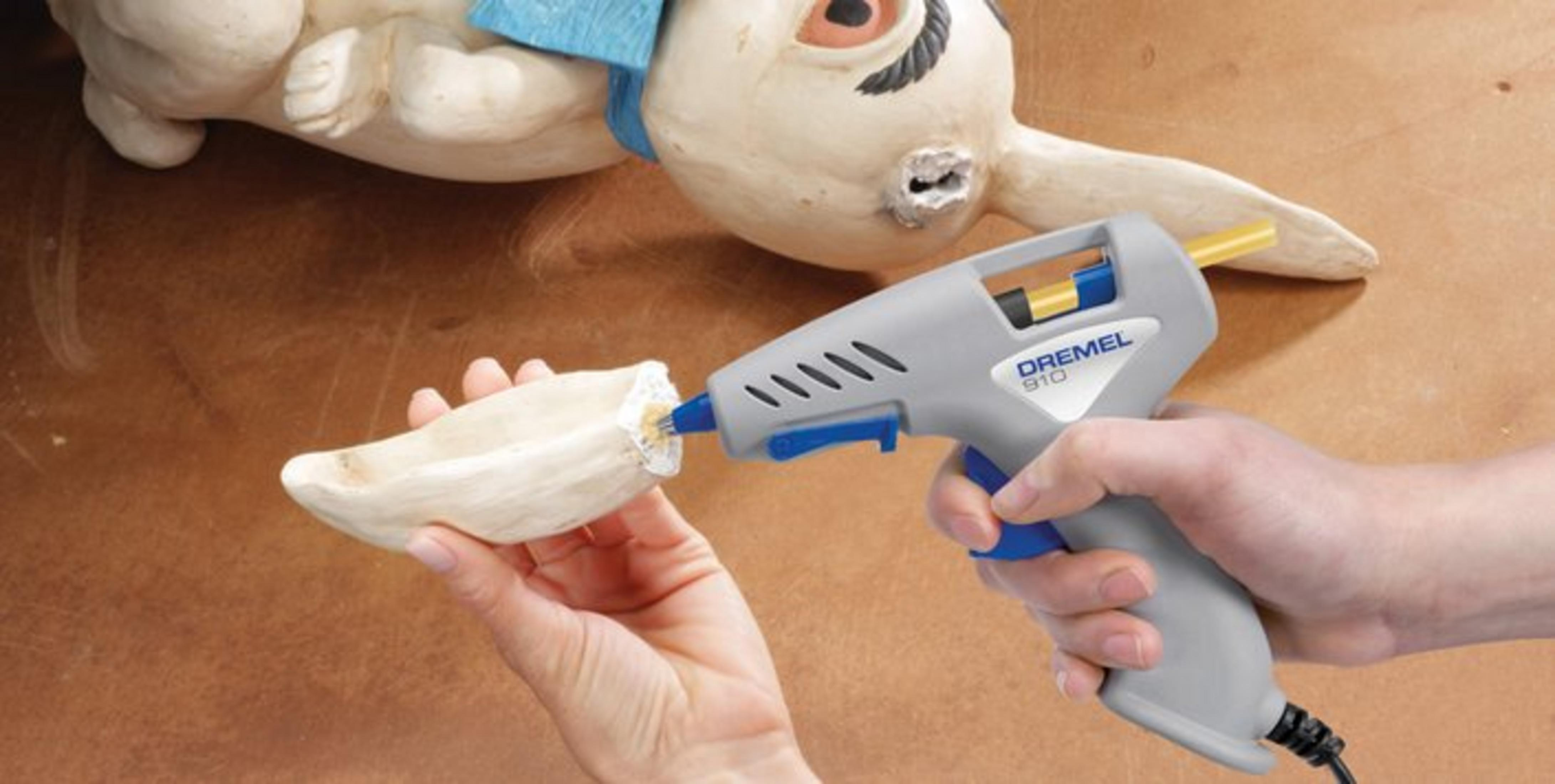 Dremel sıcak silikon tabancası, bej seramik tavşan heykelini onarıyor.