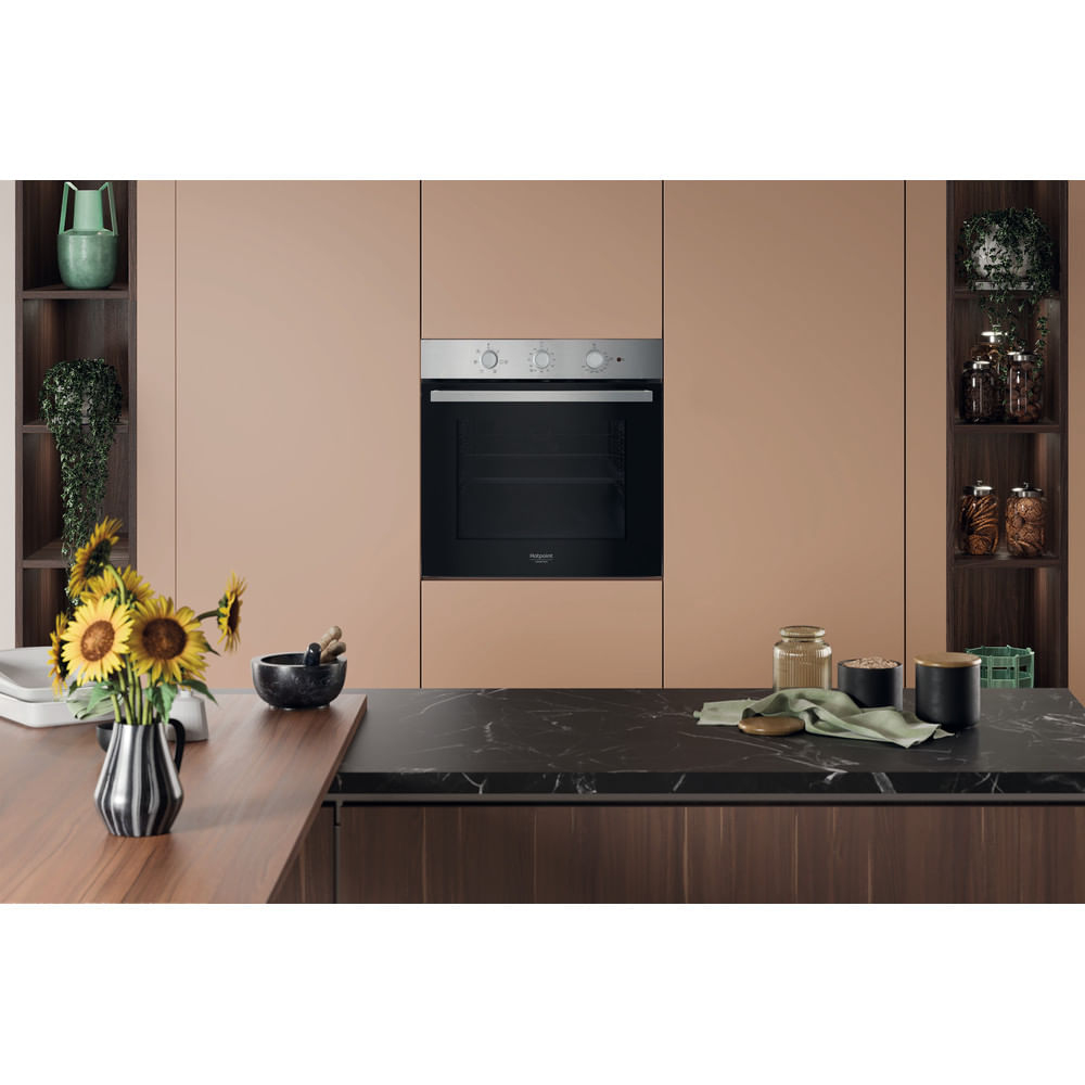 Un forno da incasso moderno in una cucina con mobili color cuoio e piano di lavoro in marmo nero.