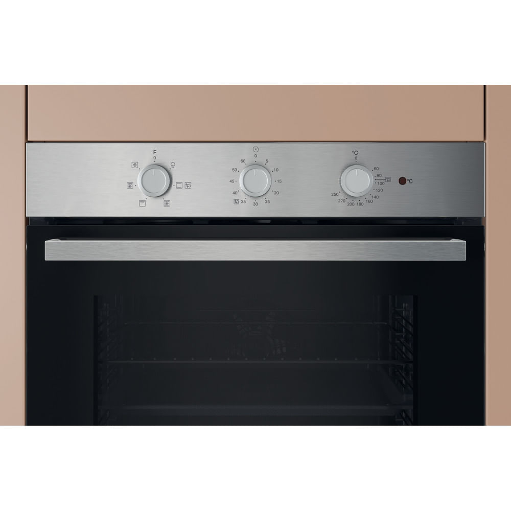 Primo piano del pannello di controllo di un forno in acciaio inox con tre manopole e simboli.