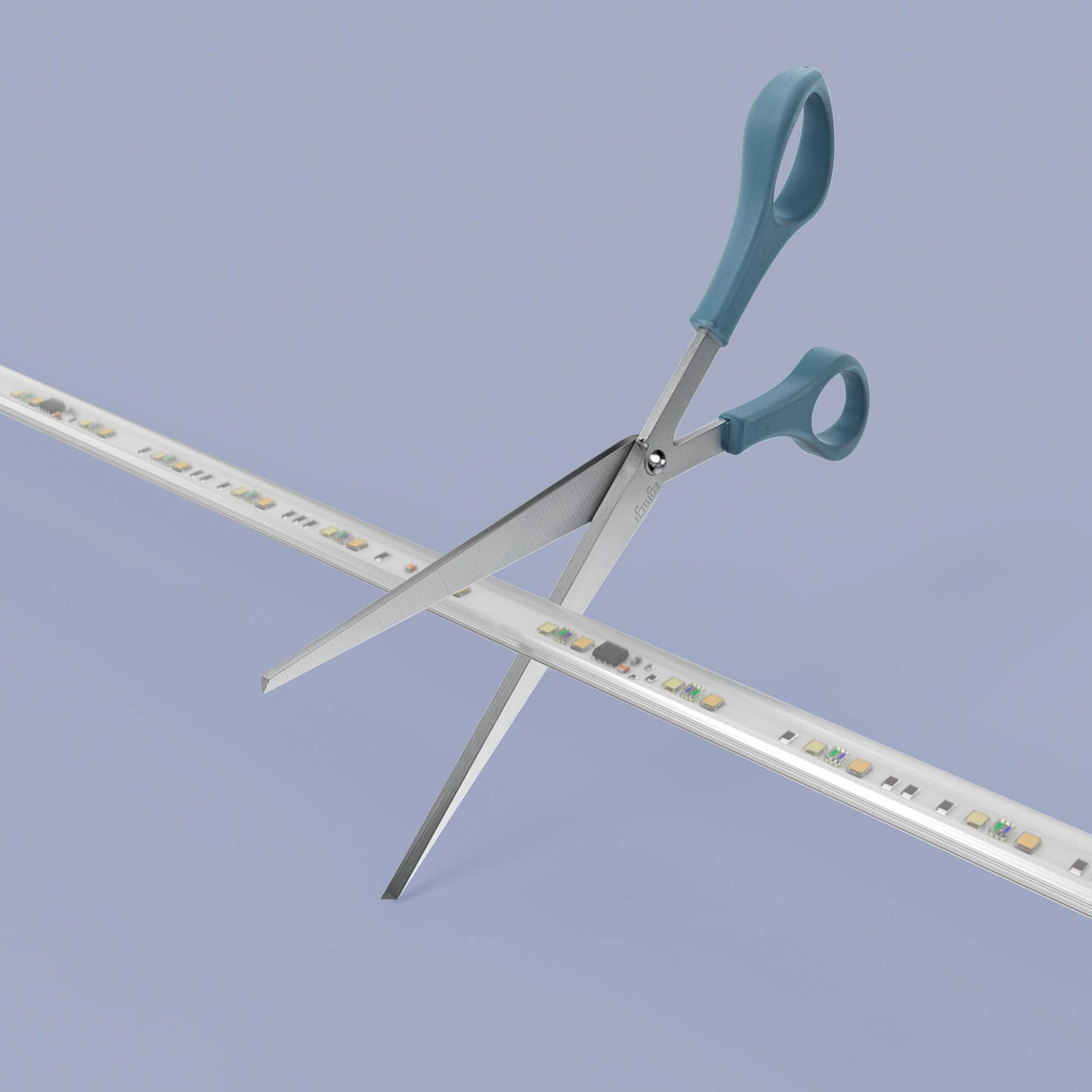 Un paio di forbici taglia una striscia luminosa a LED su sfondo blu.