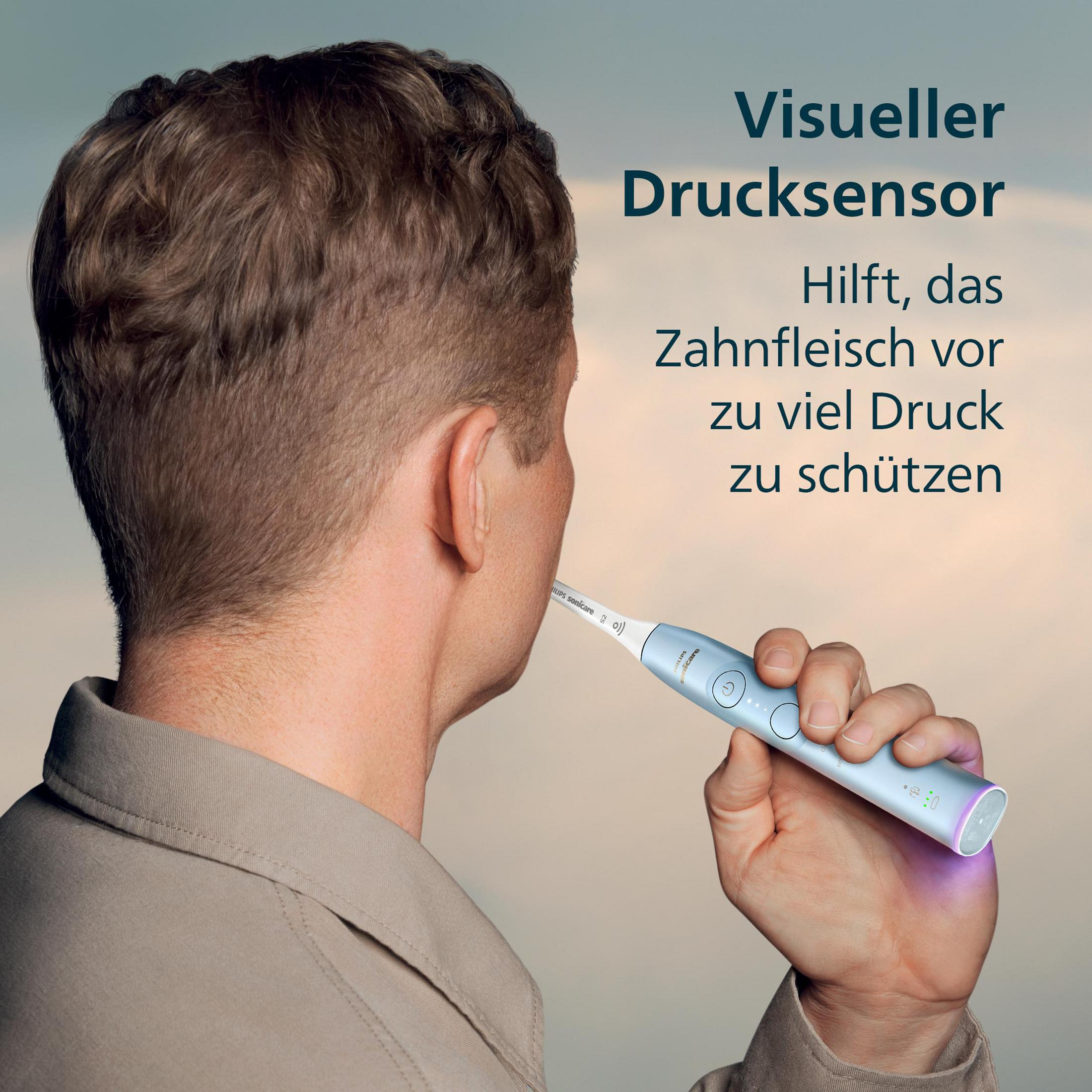 Mann hält hellblaue Schallzahnbürste mit visuellen Drucksensor