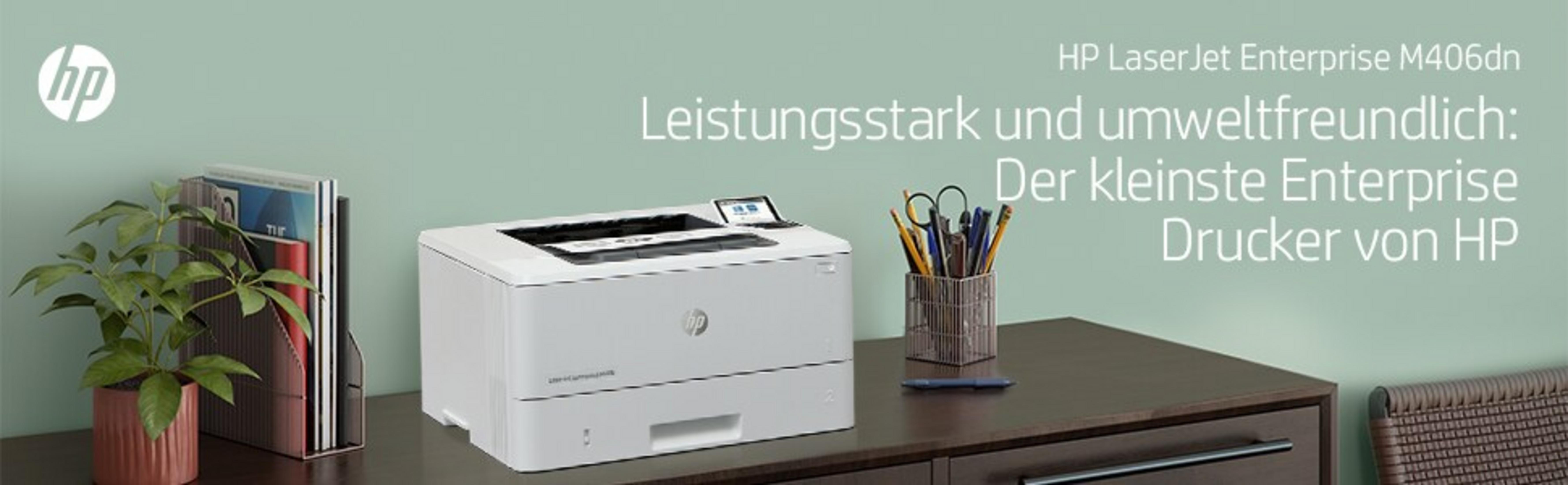 Ein weißer HP Drucker steht auf einem Schreibtisch mit einem Pflanzenhalter und Stiften.