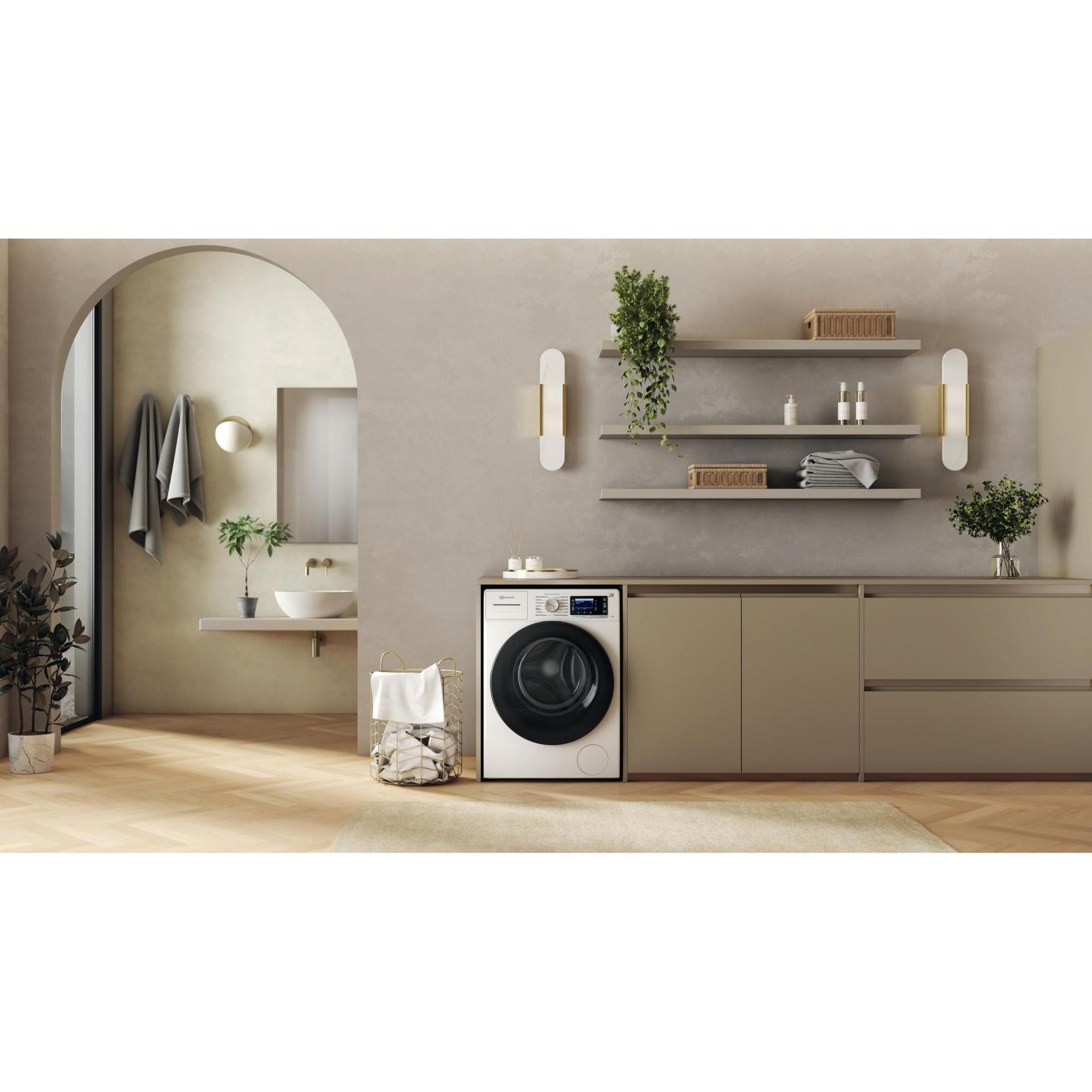 Ein moderner Waschraum mit Waschmaschine, Wäschekorb, Waschbecken und Pflanzen.