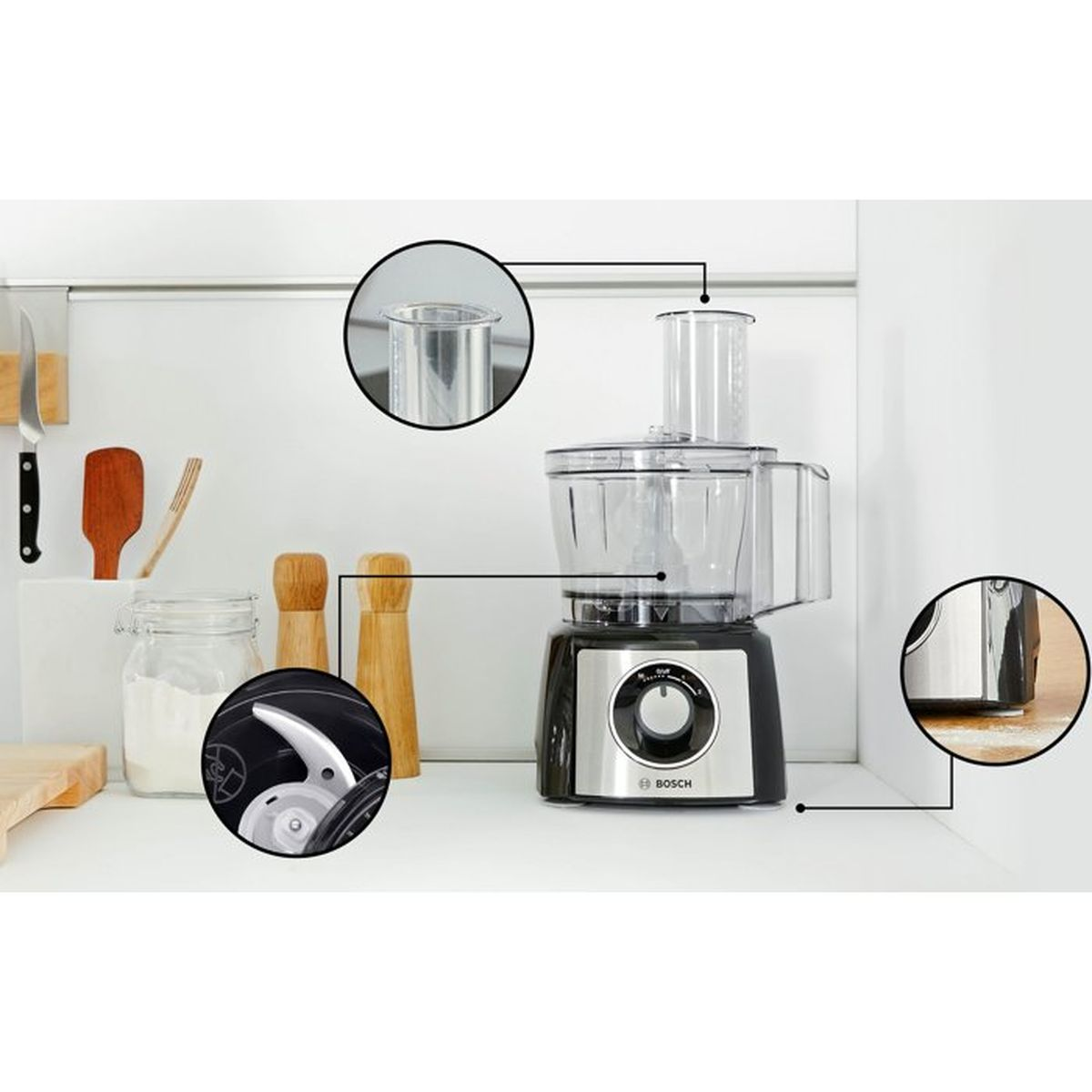 A Bosch food processor with accessories, jars, and spice grinders on a countertop.