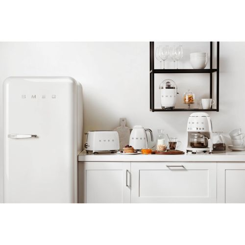 Eine weiße Küche mit einem Kühlschrank, Toaster, Kaffeemaschine und Wasserkocher.