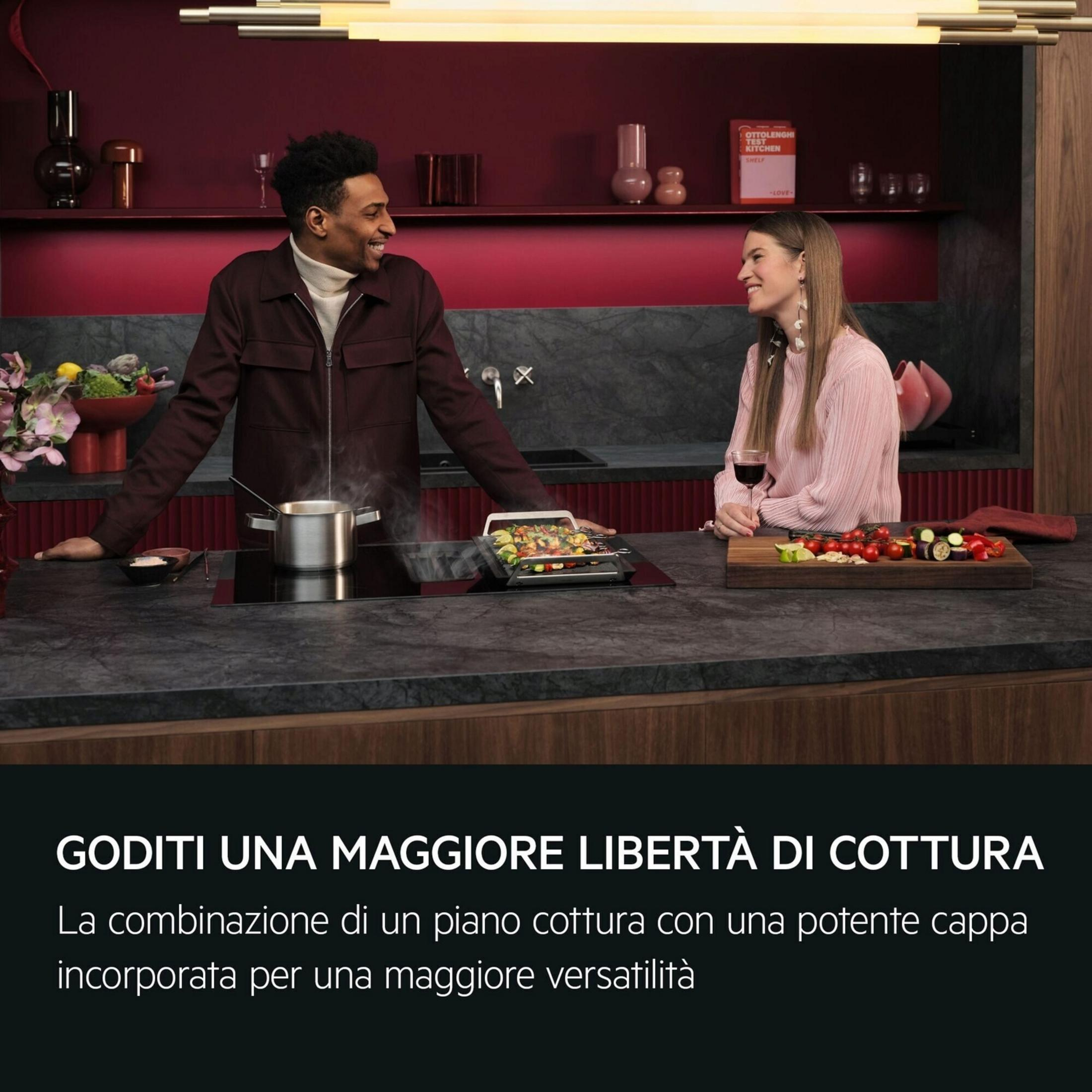 Un hombre y una mujer se sonríen en una cocina moderna.