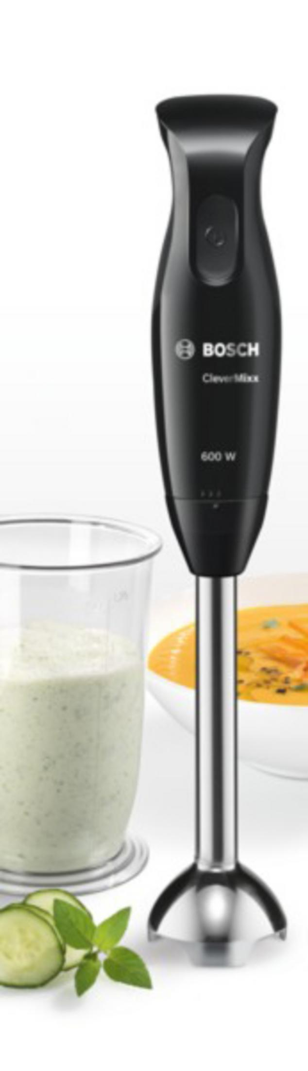 Schwarzer Stabmixer neben Glas mit grünem Smoothie, Gurkenscheiben und Minze.
