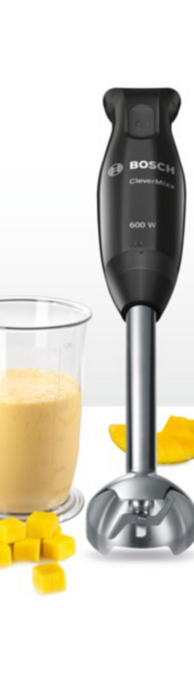 Ein schwarzer Stabmixer neben einem Glas mit gelbem Smoothie und Mangostücken.