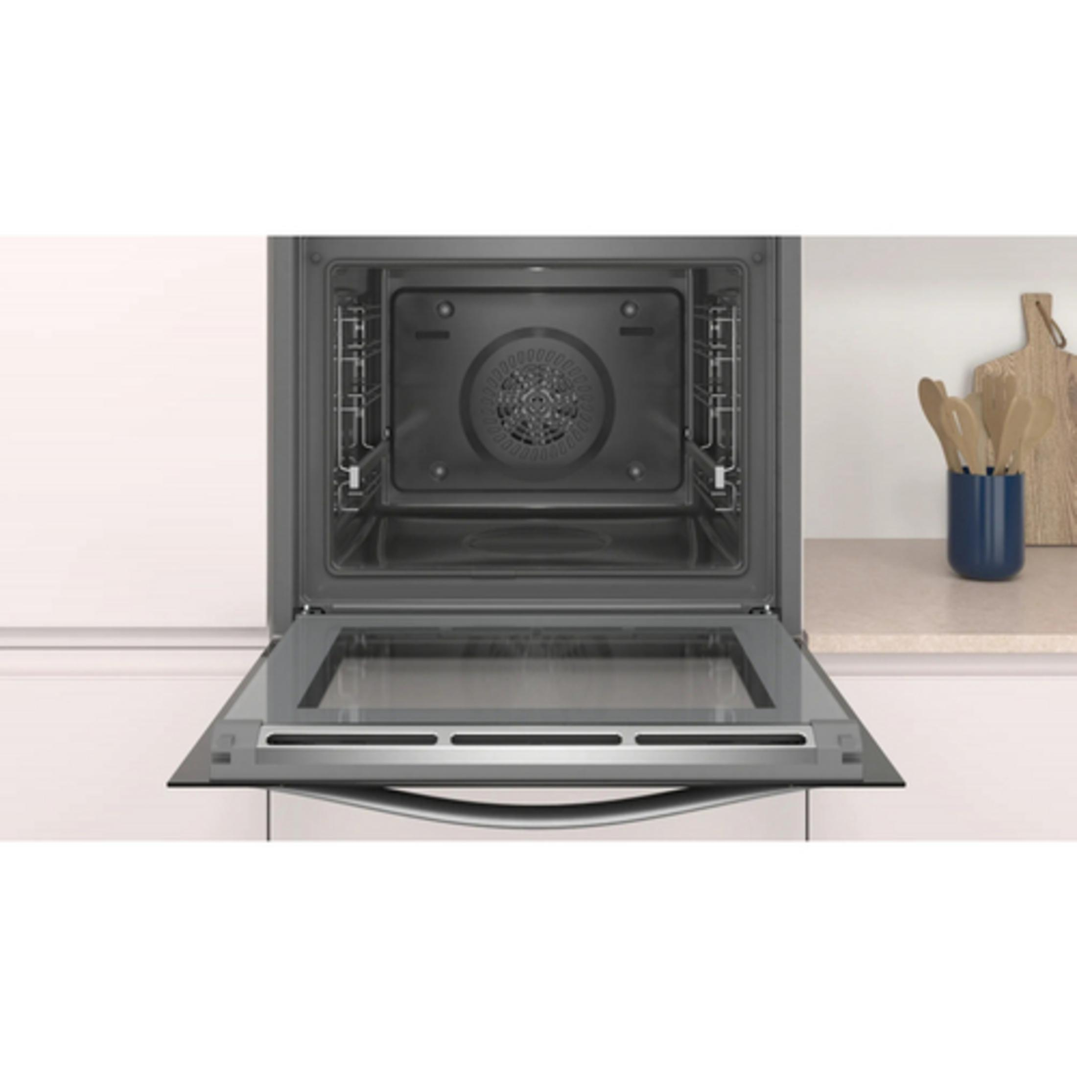 Un horno moderno con la puerta de cristal abierta, mostrando el interior.