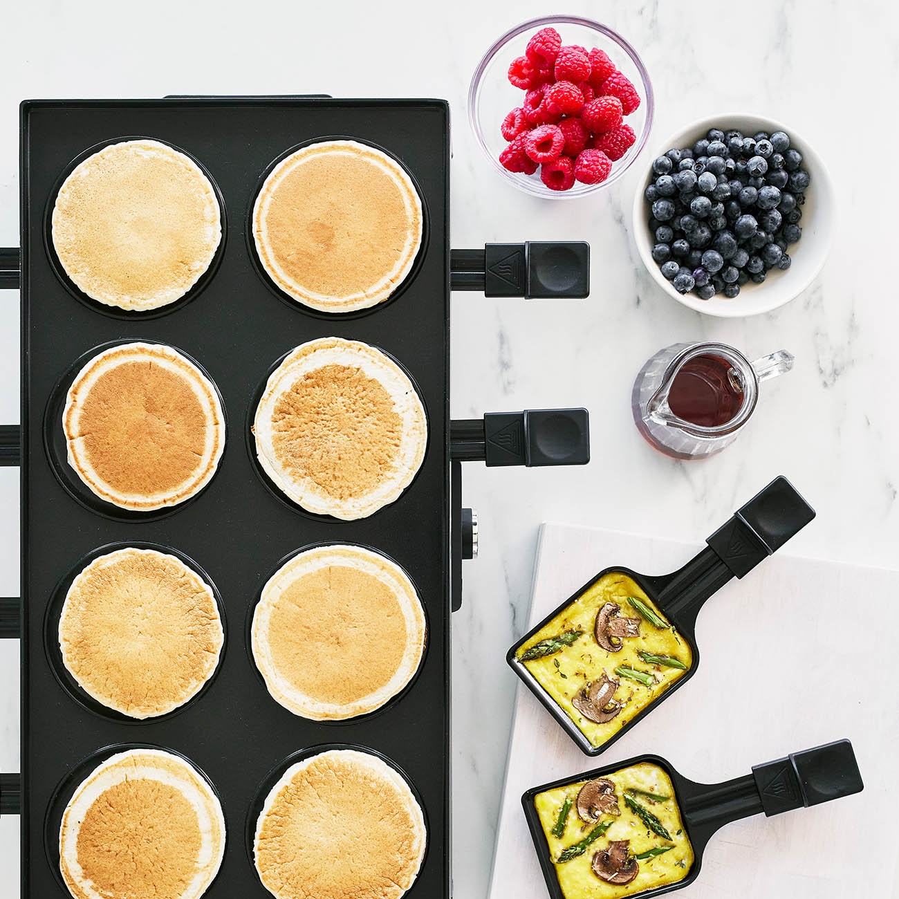 Pfannkuchen auf einer Platte mit Beeren und Omeletts.