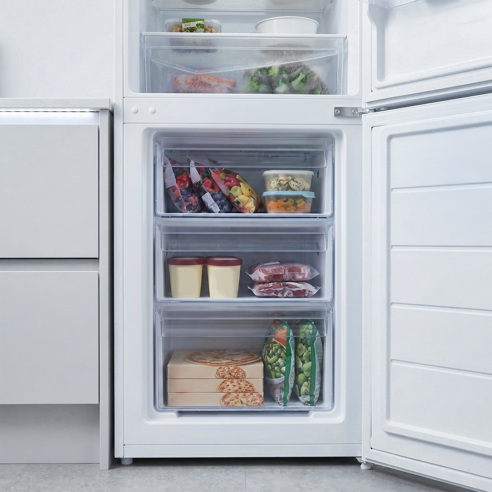 Ein offener weißer Kühlschrank mit mehreren Schubladen, gefüllt mit Lebensmitteln.