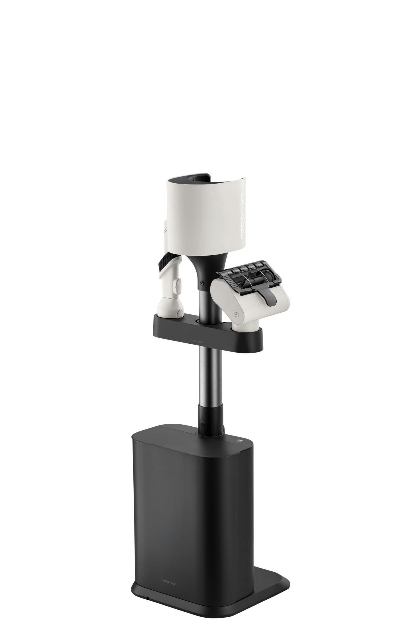 Soporte de aspiradora blanco y negro con accesorios.