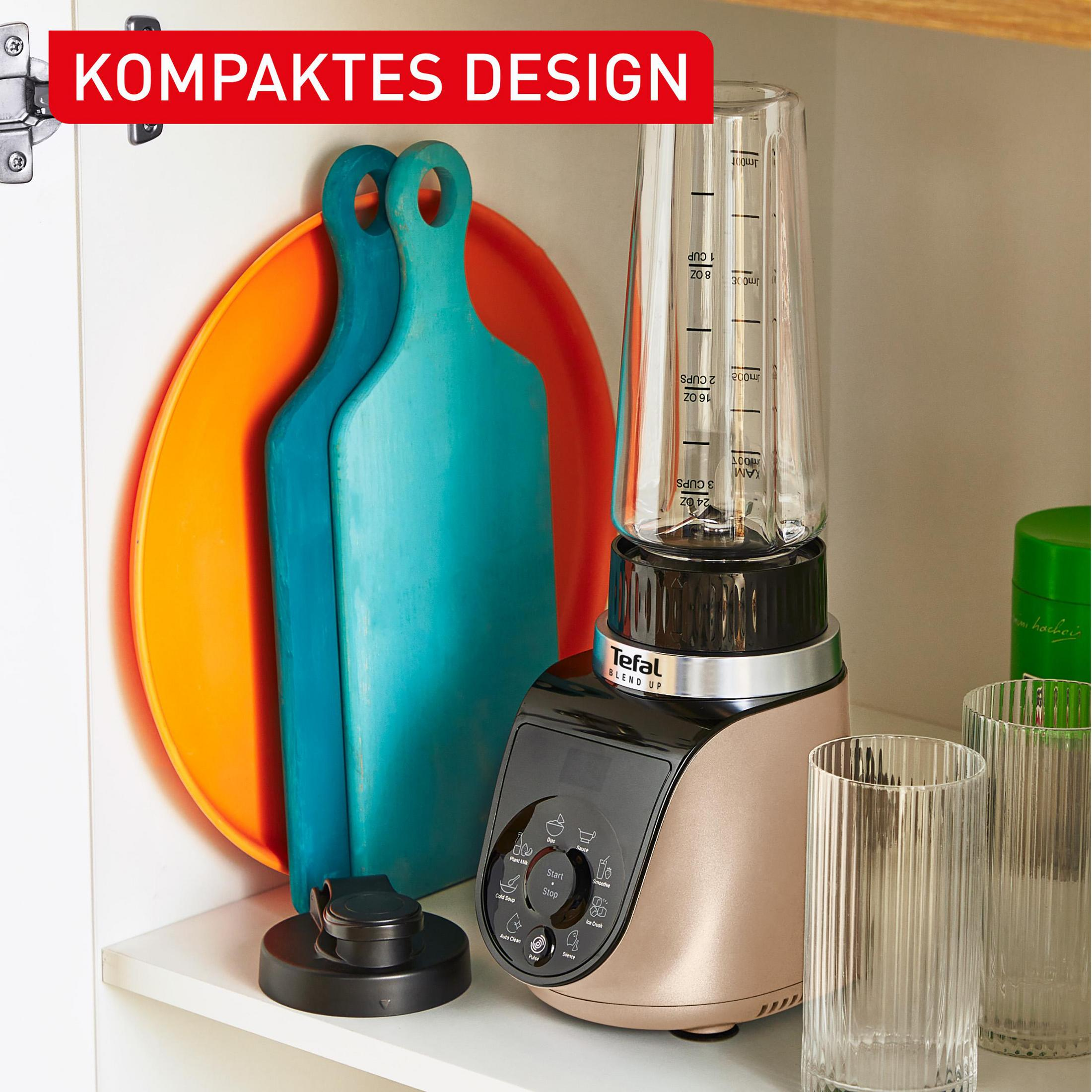 Ein Tefal Standmixer mit Glasbehälter steht neben Schneidebrettern und Gläsern.