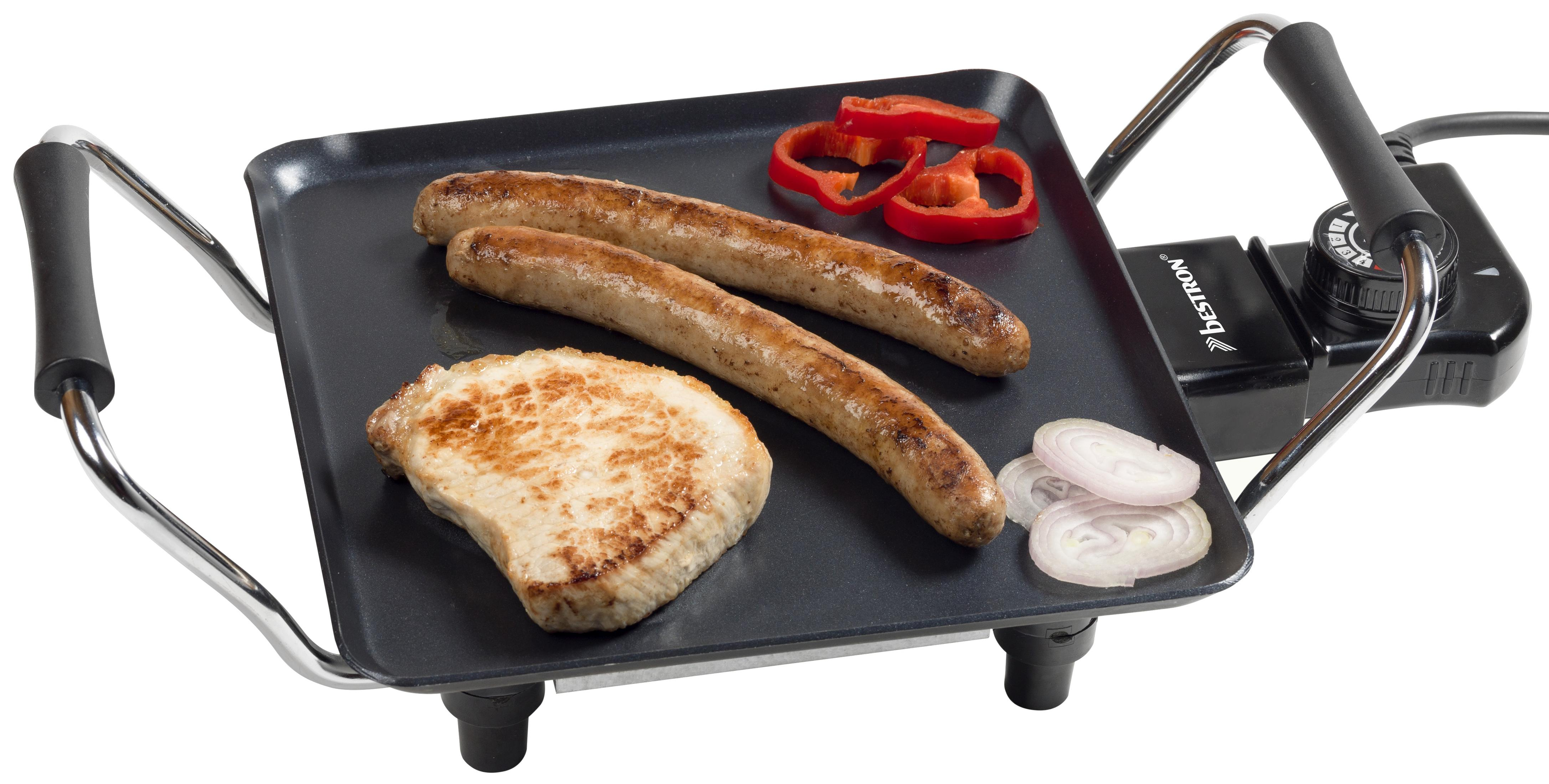 Zwei Würstchen, ein Schnitzel, Paprika und Zwiebelringe auf einer Grillplatte.