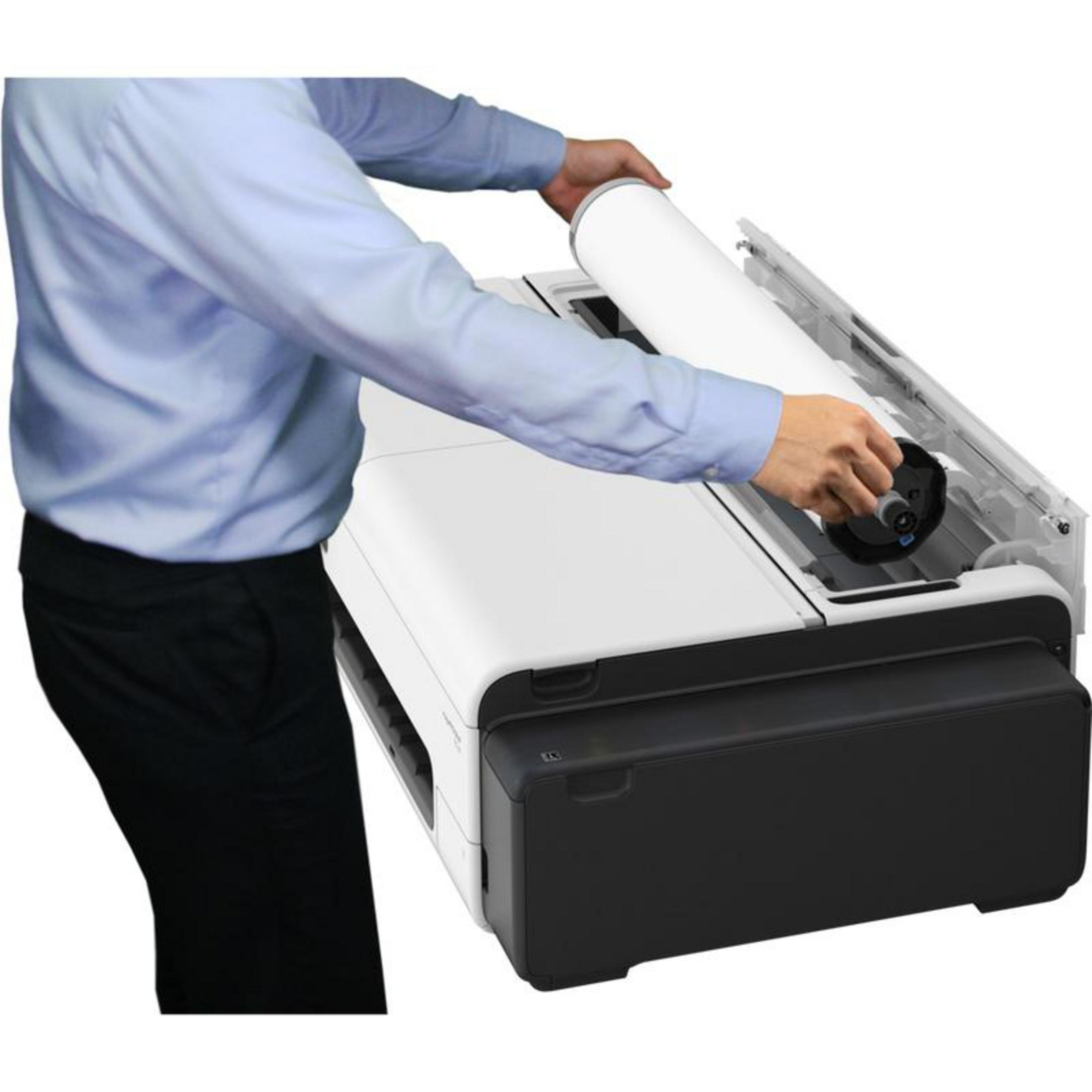 Een man in een blauw hemd en zwarte broek plaatst een grote witte rol in een printer.