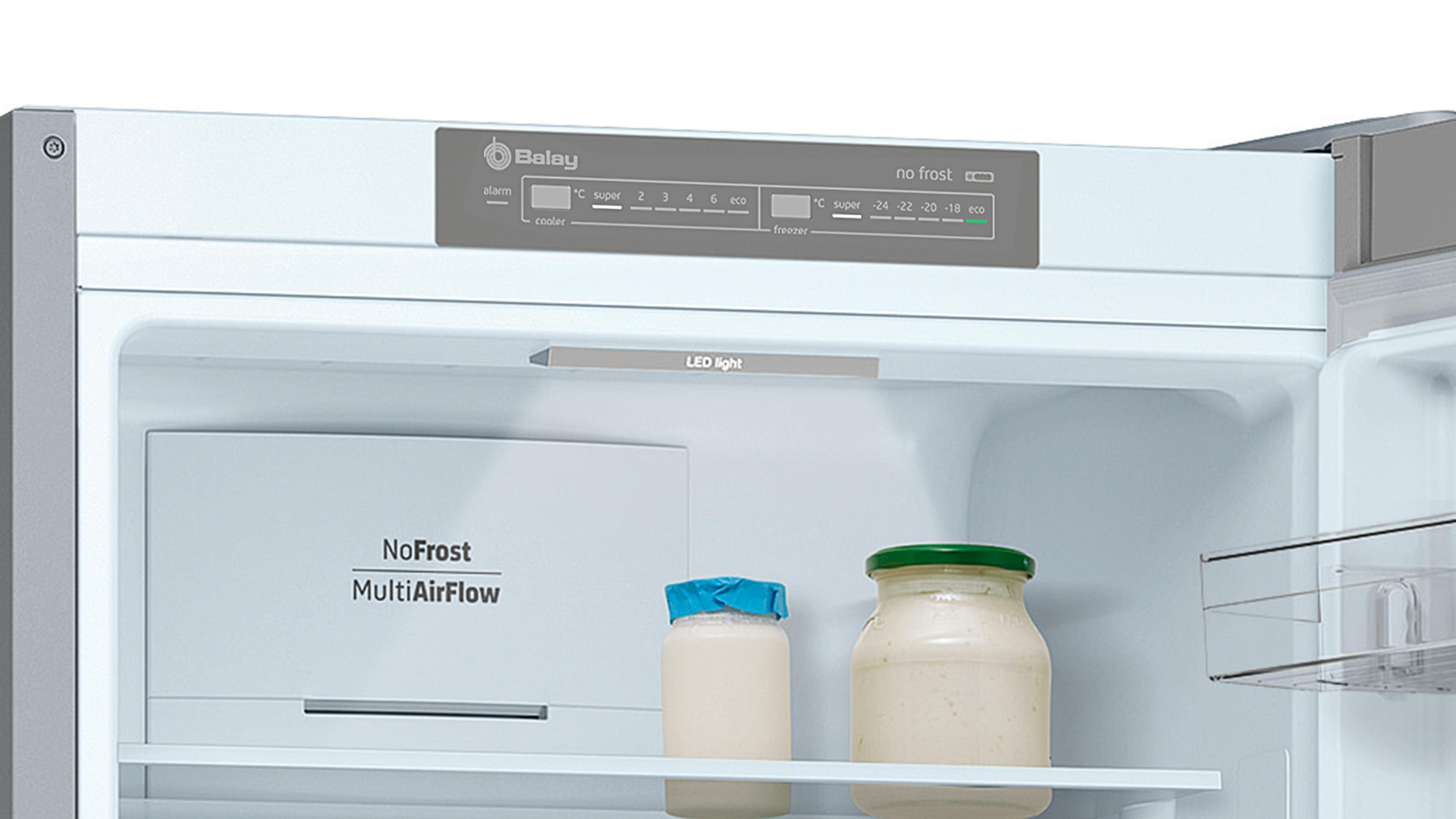 Vista interior de un refrigerador con dos frascos y pantalla "NoFrost".