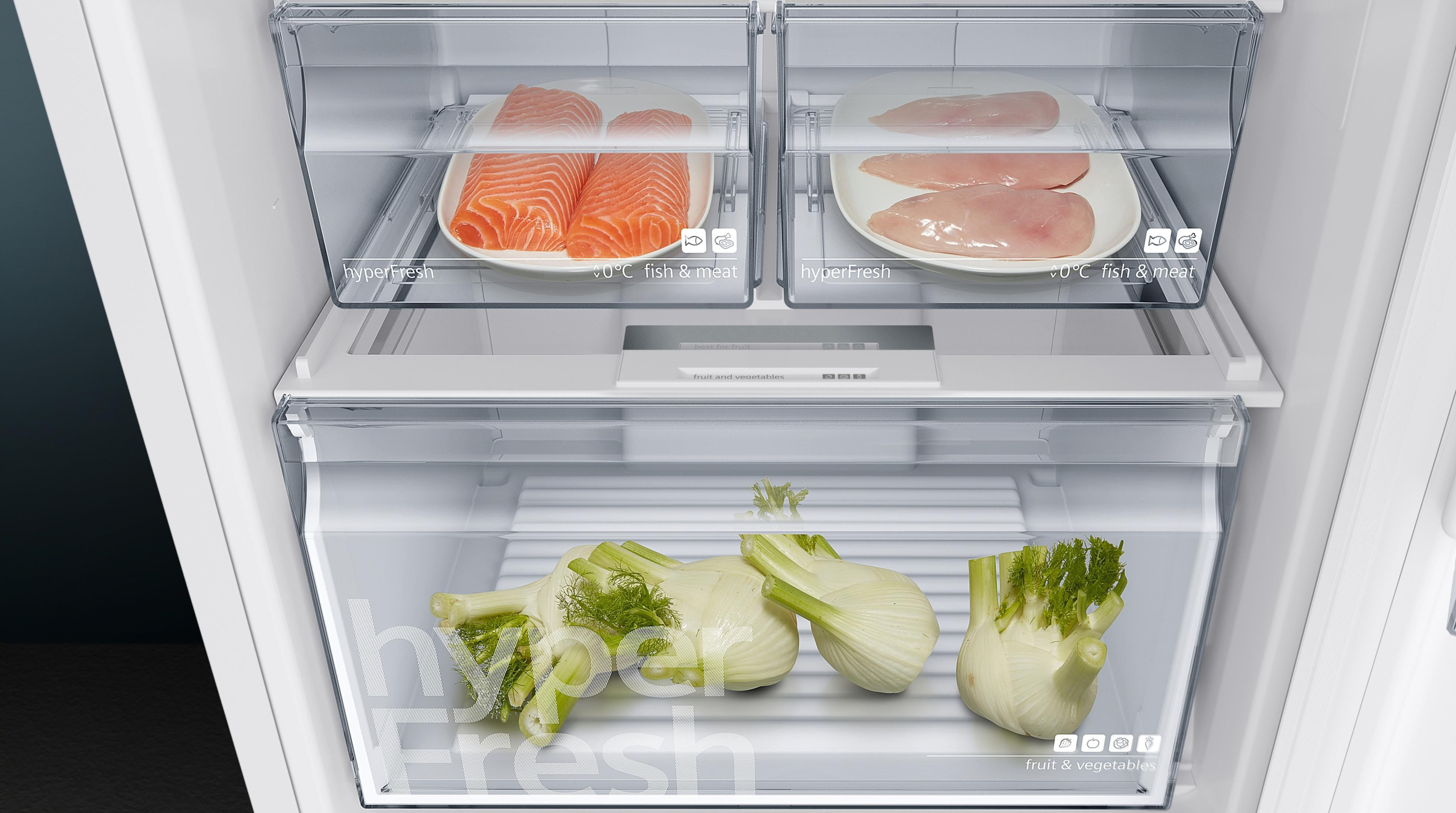 Cajones frescos con salmón, pechuga de pollo y hinojo en un refrigerador.