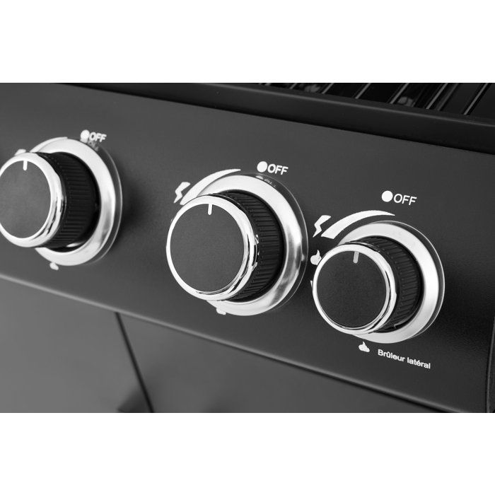 Drei schwarze Drehregler mit silbernen Ringen auf einem schwarzen Grill.