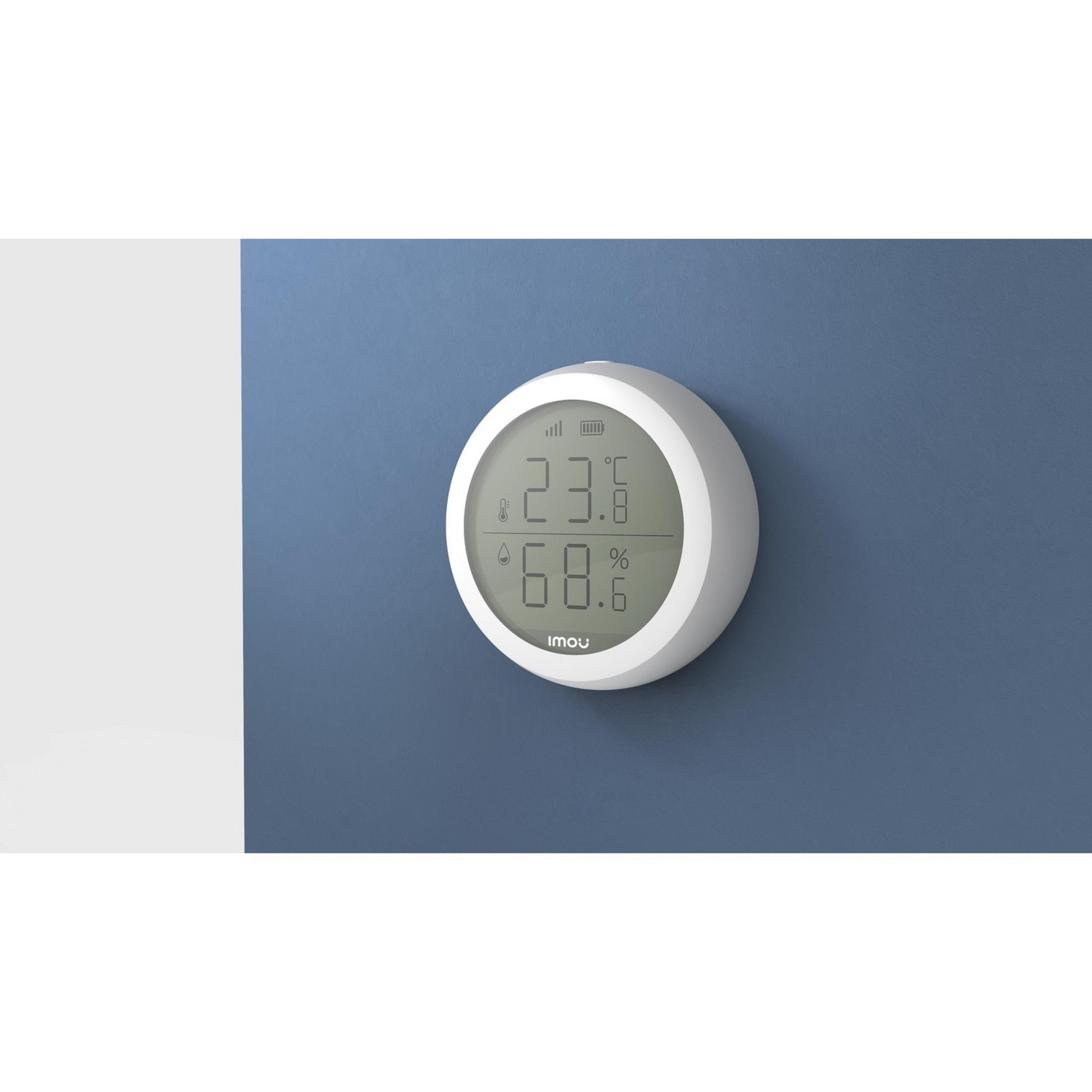 Un termometro digitale bianco che mostra temperatura e umidità.