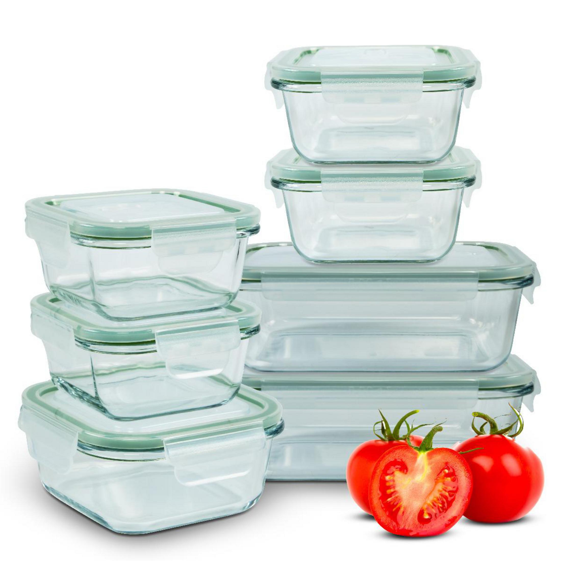 Vari contenitori rettangolari in vetro con coperchi verdi, due pomodori accanto.