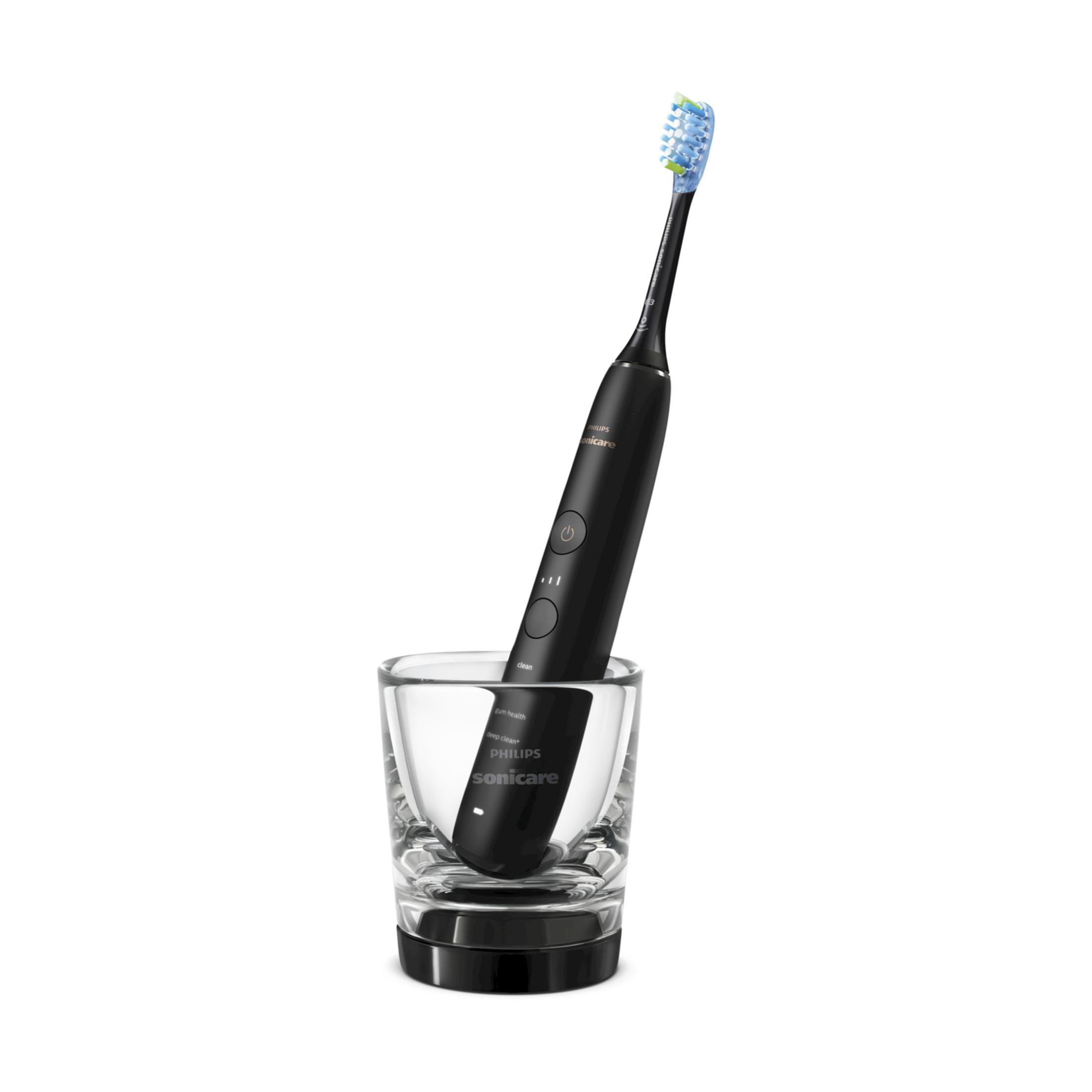 Cepillo de dientes sónico negro con cabezal azul-verde en vaso.