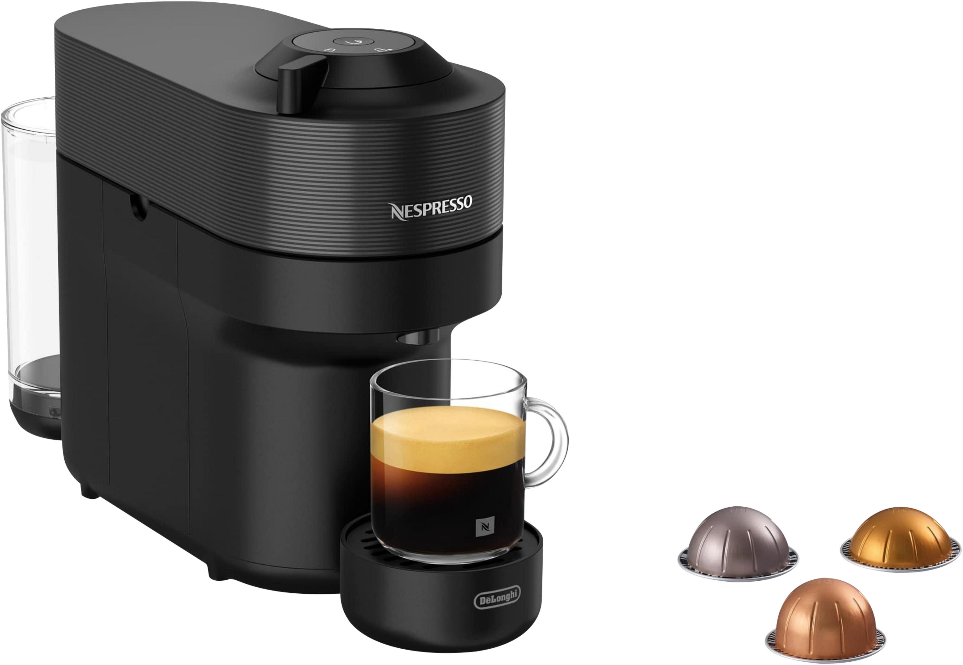 Macchina da caffè Nespresso nera con tazza di espresso e tre capsule di caffè.