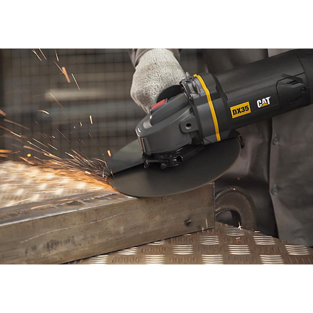 Eine behandschuhte Hand benutzt eine schwarz-gelbe CAT-Winkelschleifmaschine zum Schneiden von Metall, Funken entstehen.