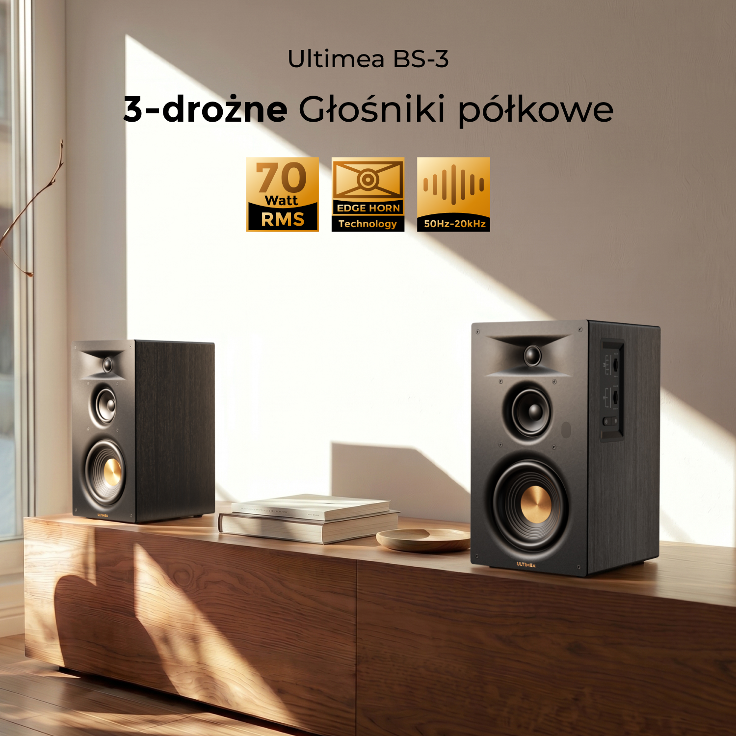 Dwa czarne głośniki na drewnianej szafce. Napis: Ultimea BS-3, 70 Watt RMS.