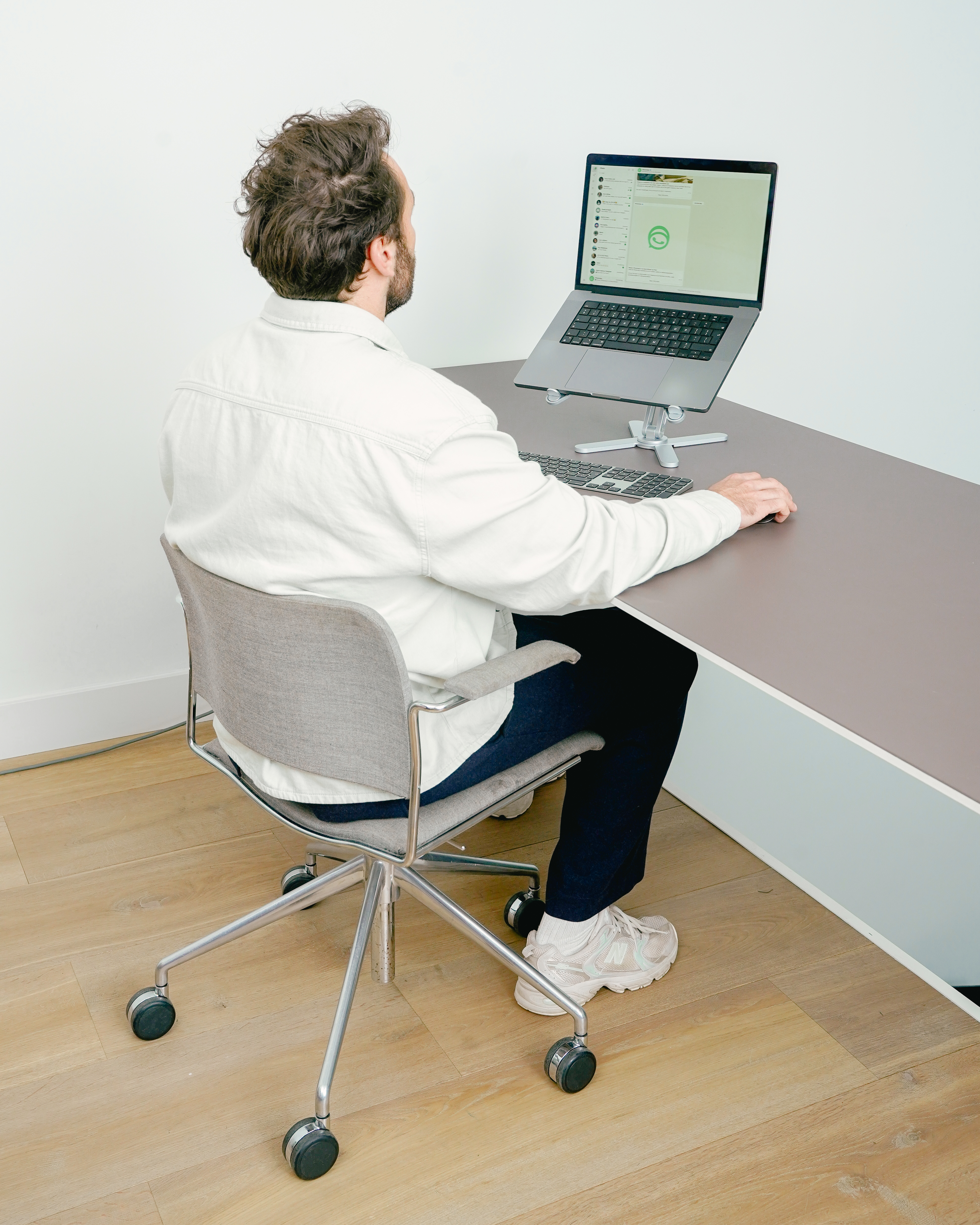 Man zit aan een bureau en gebruikt een laptop met extern toetsenbord.
