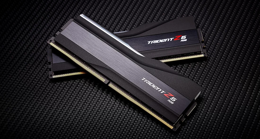 Dwa czarne moduły RAM Trident Z5 RGB na czarnej teksturowanej powierzchni.