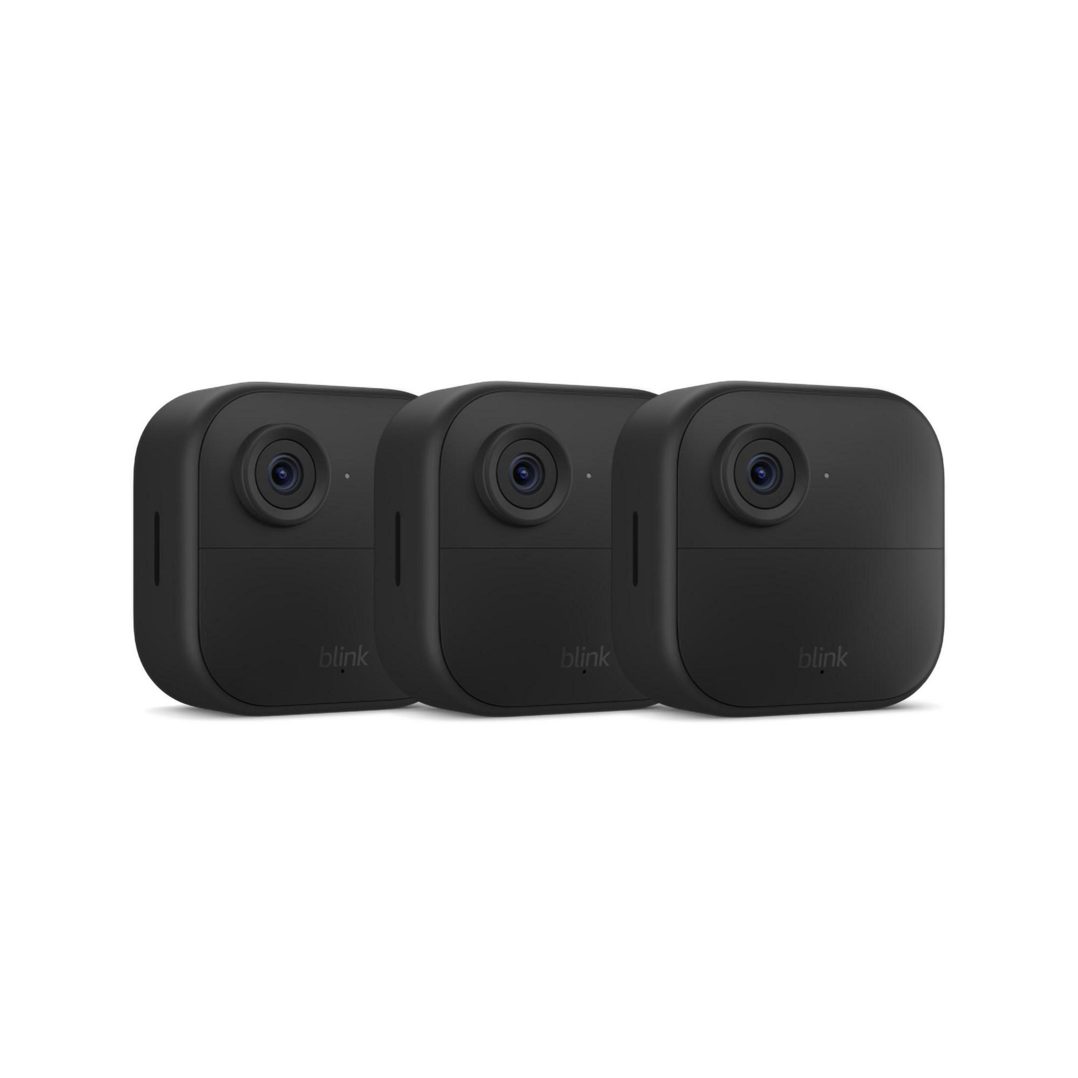 Tre telecamere di sicurezza Blink nere disposte fianco a fianco su sfondo bianco.