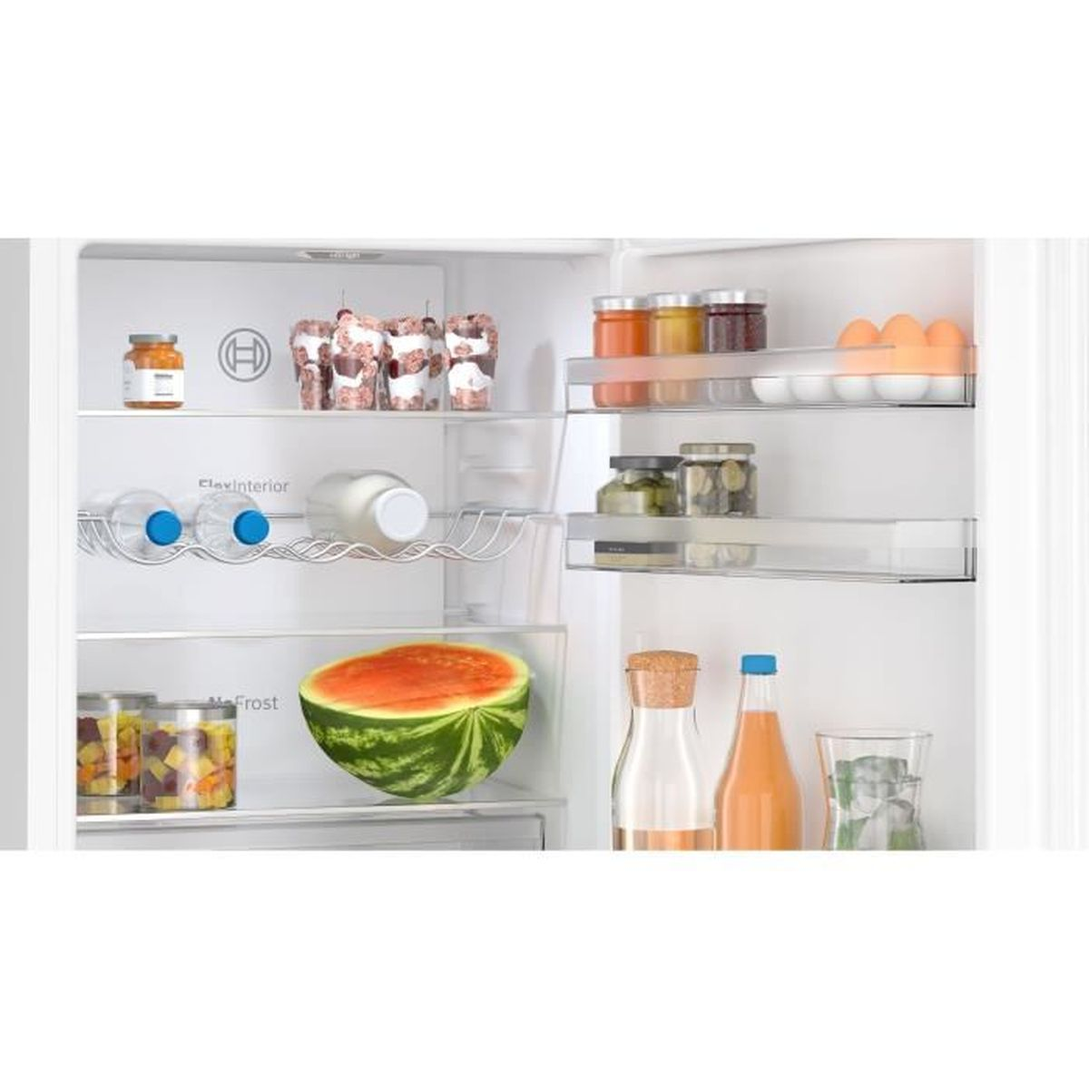 Interno di un frigorifero con alimenti: anguria, uova, bottiglie e barattoli.