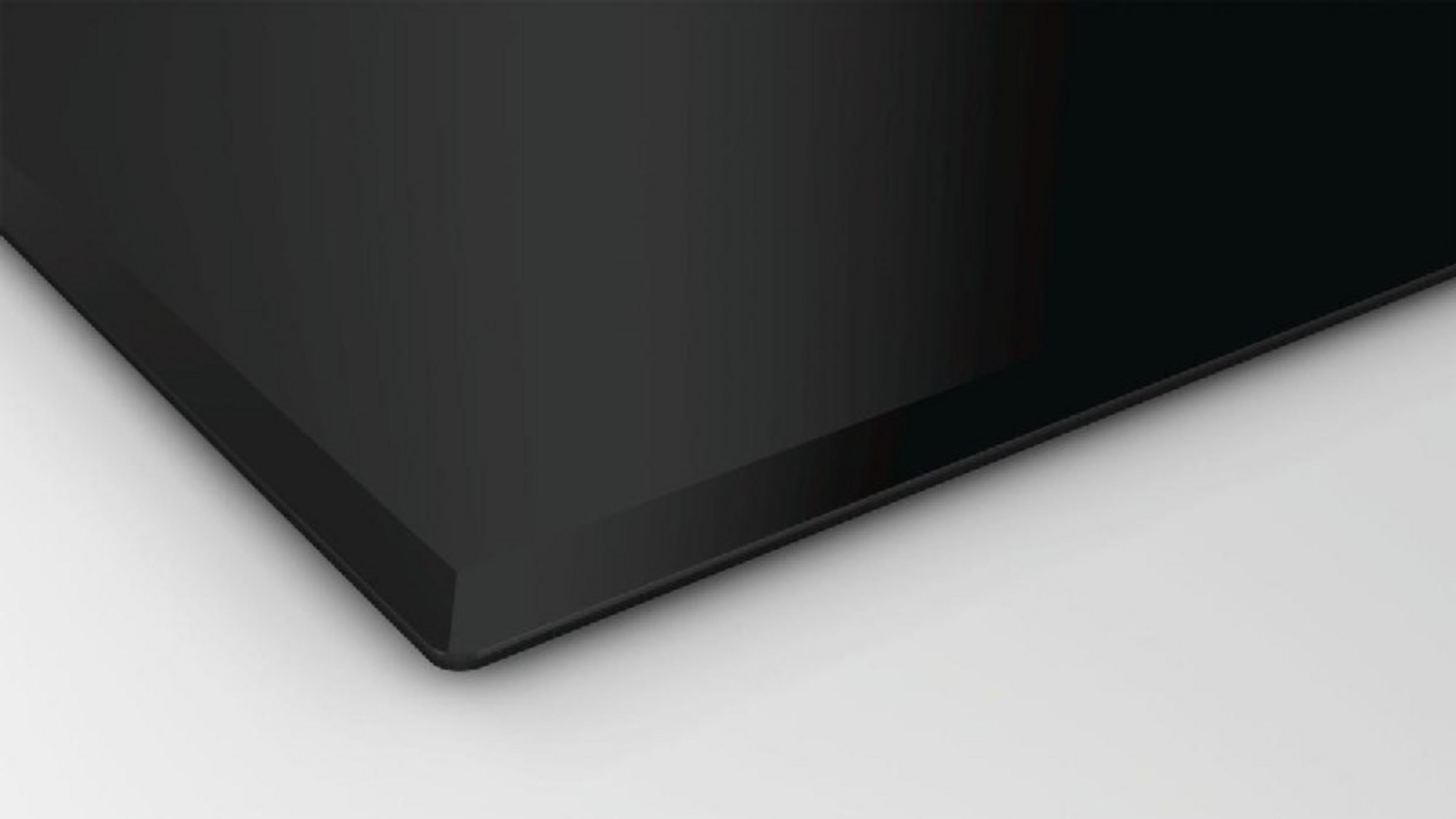 Primer plano de una superficie lisa y negra con borde plateado.