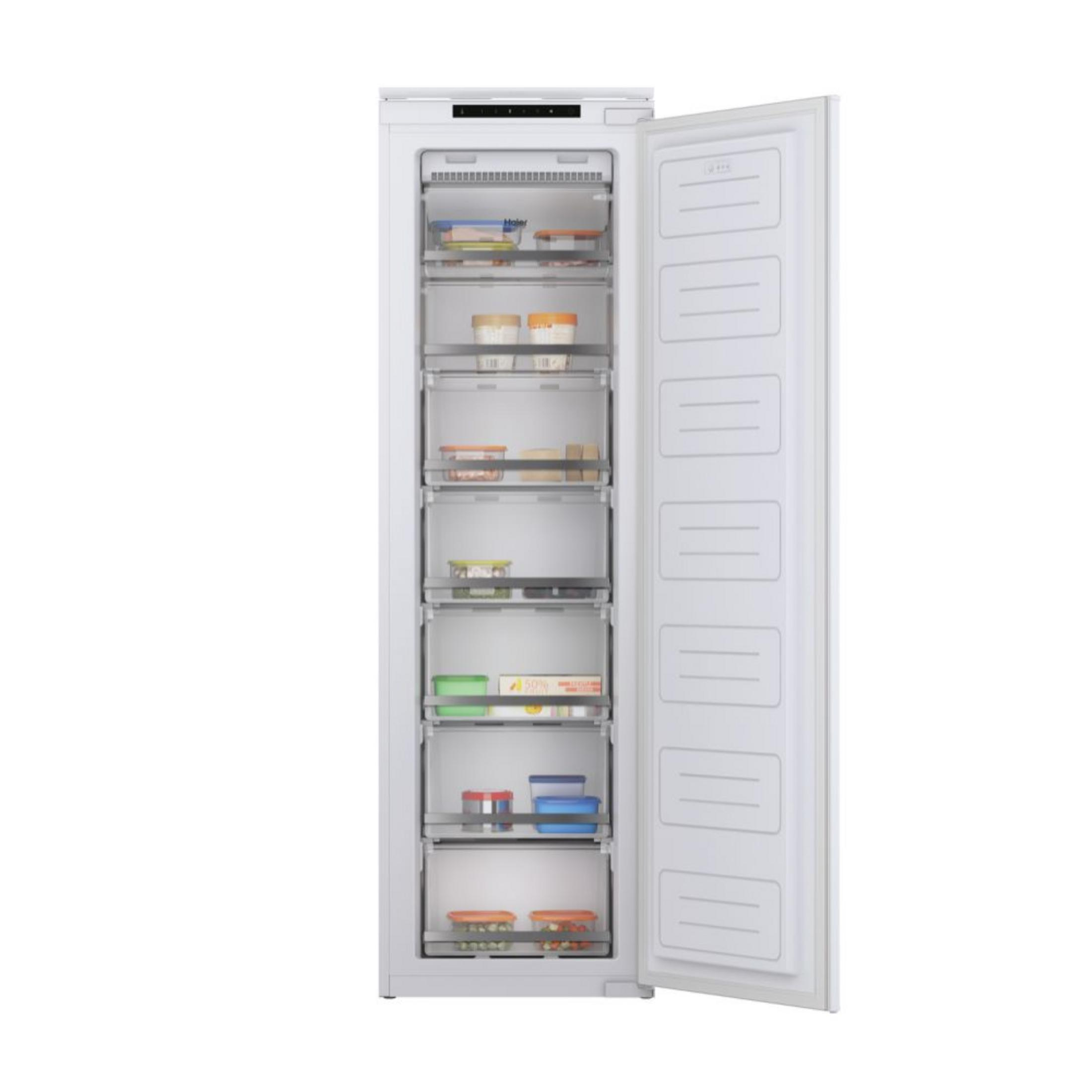 Un congelatore bianco con porta aperta, riempito di cibo in contenitori.