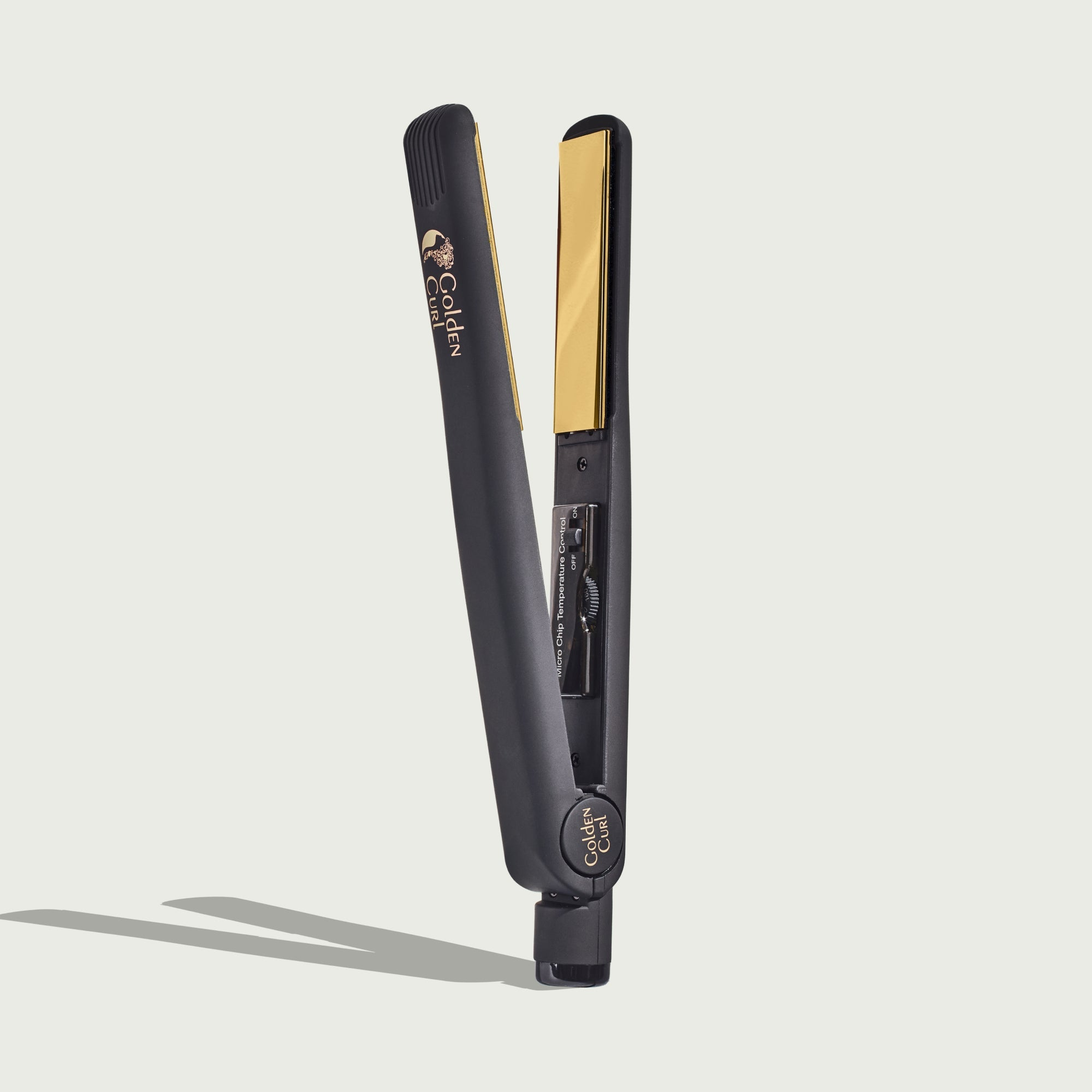 Una piastra per capelli nera con piastre dorate e logo del marchio.