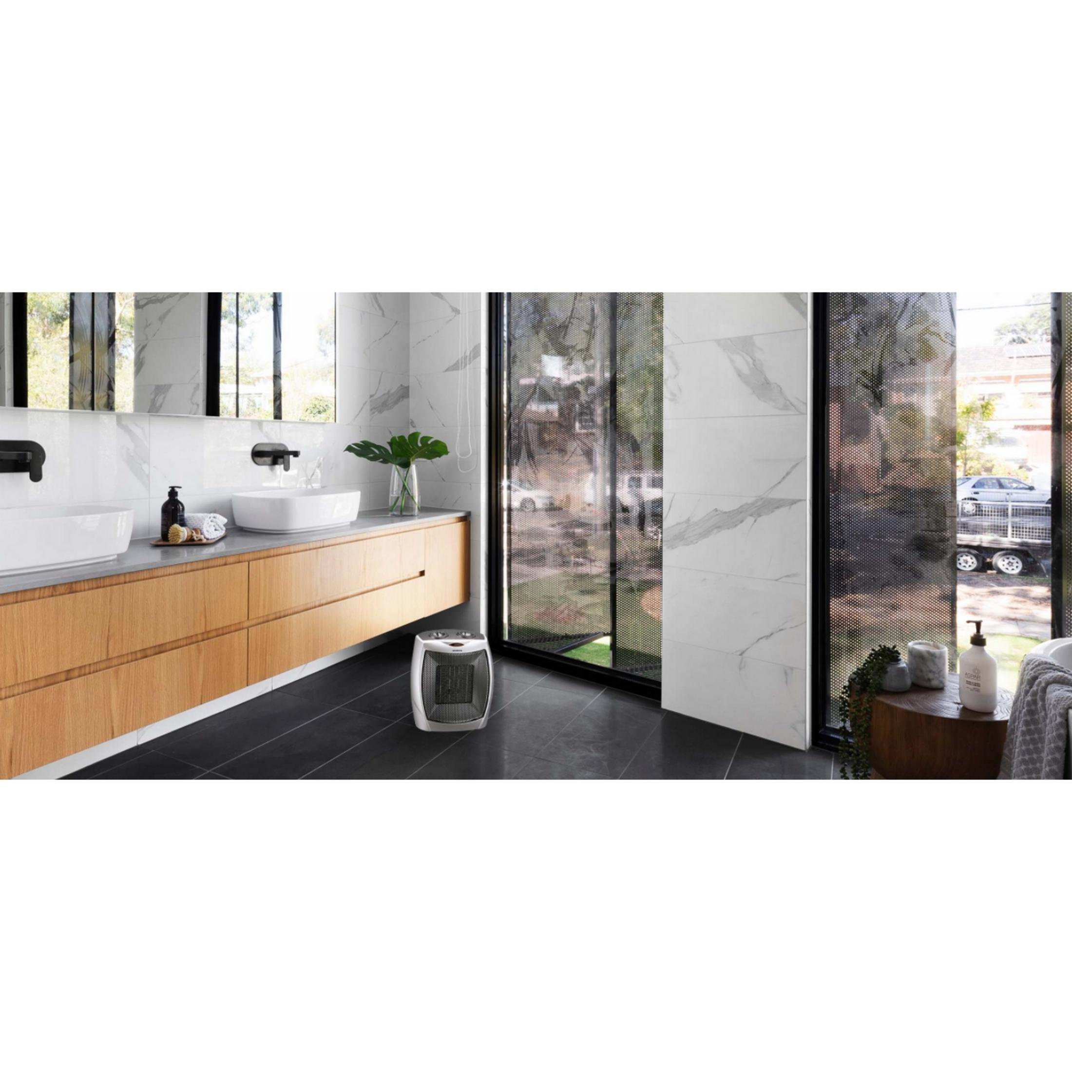 Baño moderno con tocador de madera, dos lavabos y un calentador portátil.