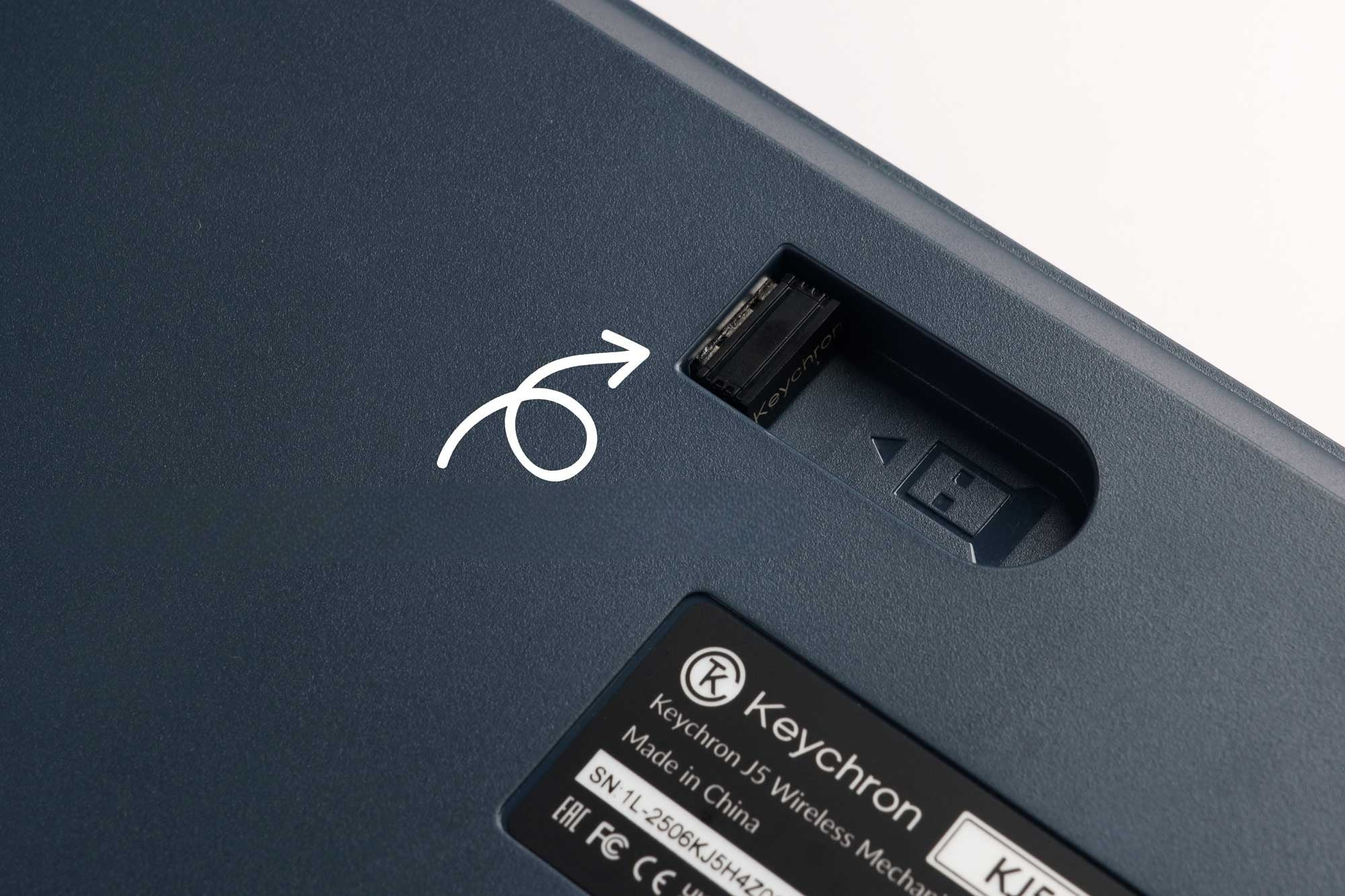 Ciemnoszare etui ze białą strzałką wskazującą na gniazdo odbiornika USB.