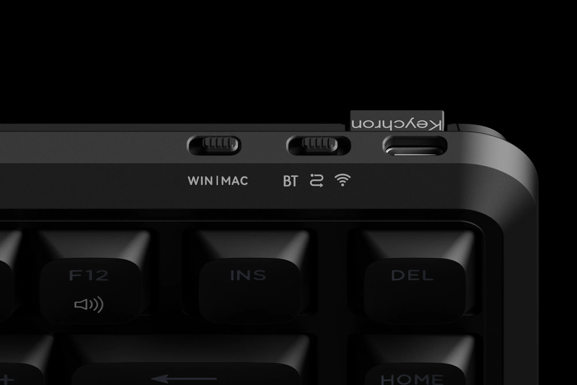 Widok z góry czarnej klawiatury z logo "Win|Mac", "BT" i "Keychron".