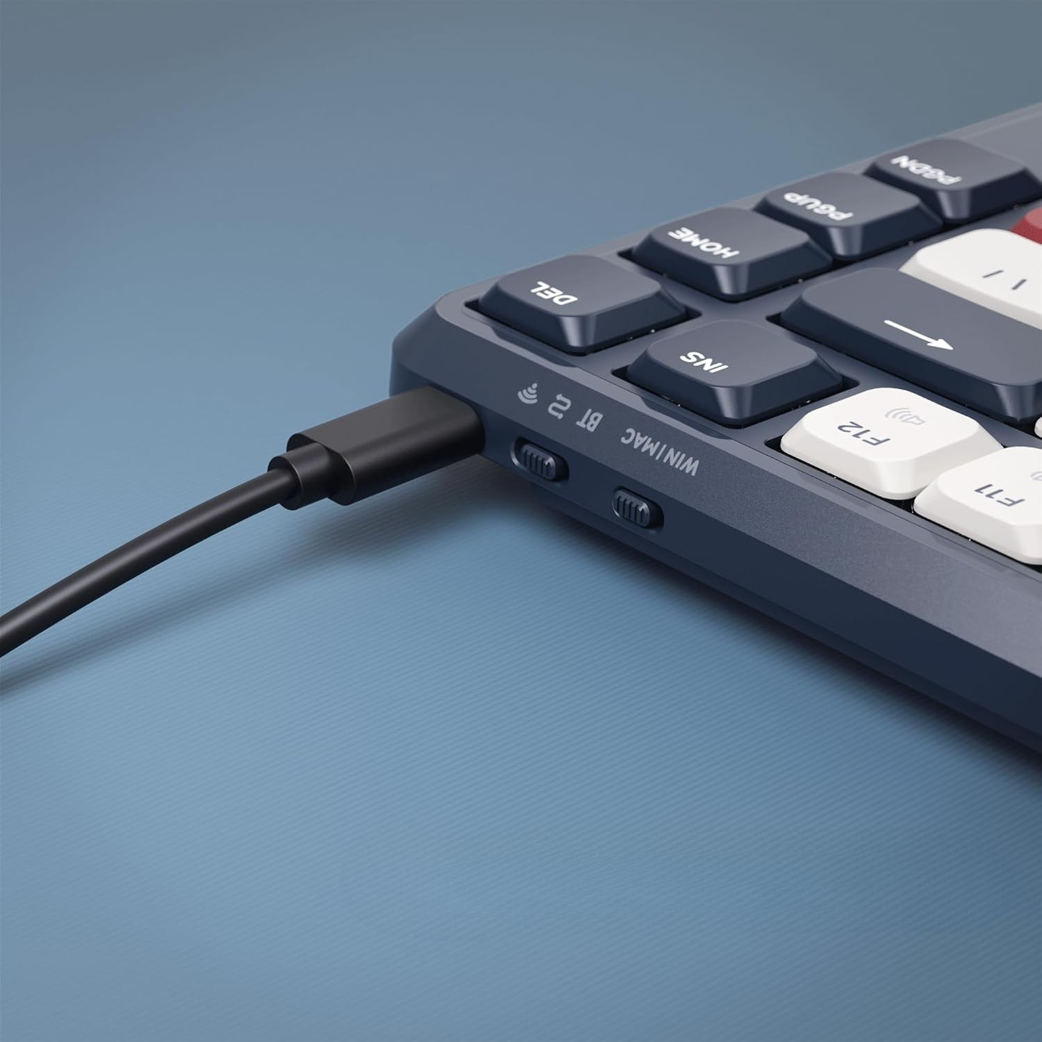 Czarny kabel USB jest podłączony do ciemnej klawiatury.