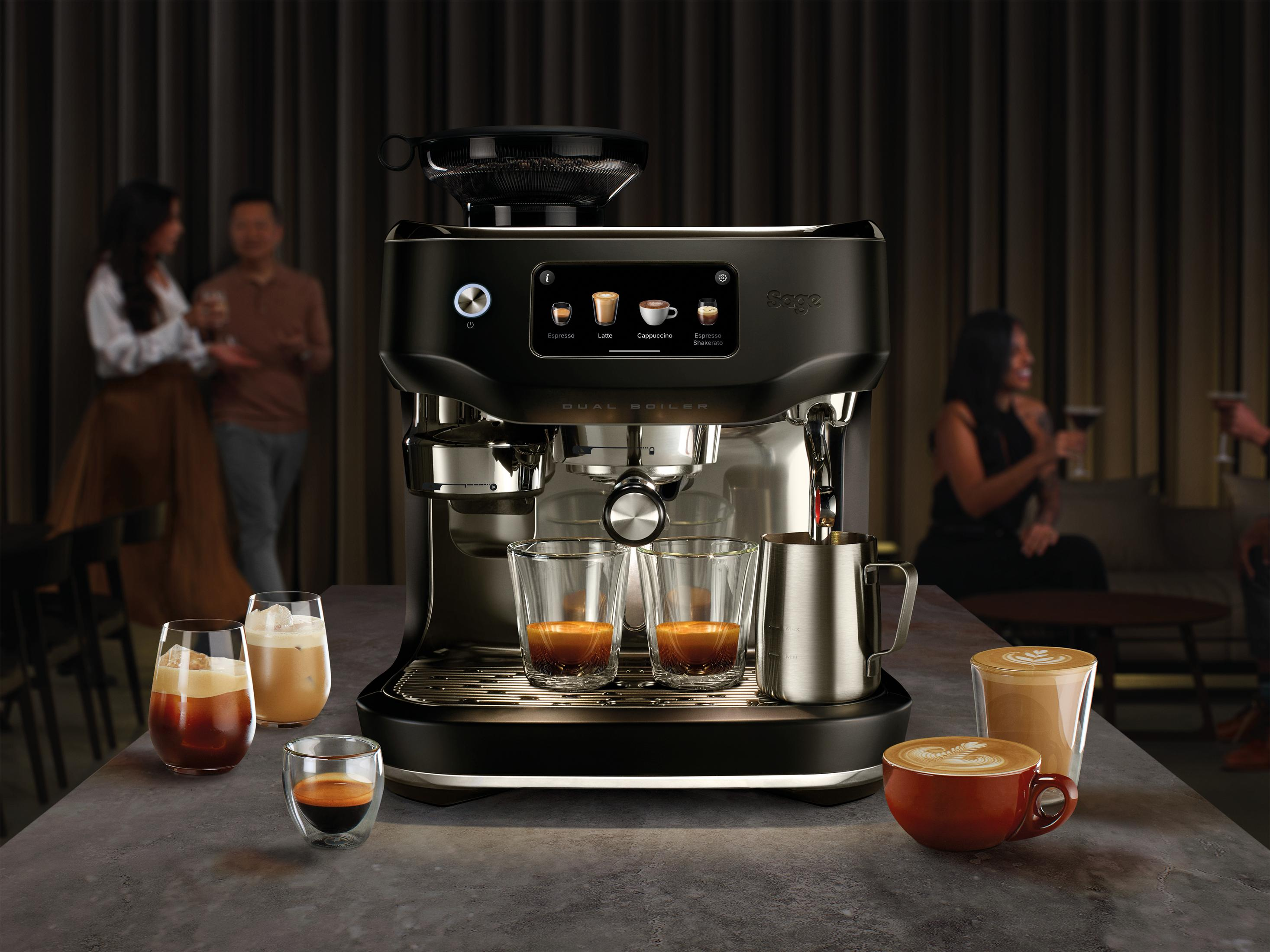 Macchina espresso nera con bevande al caffè sul tavolo. Persone sullo sfondo.