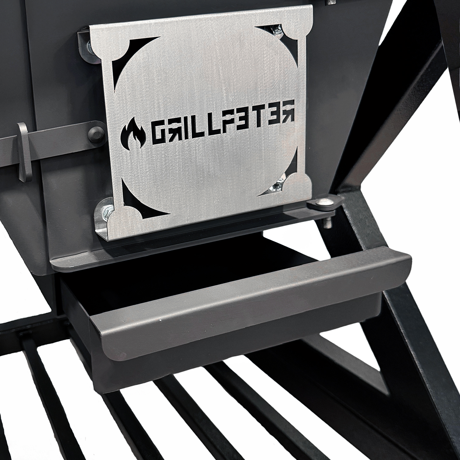 Ein Detail eines Grills mit silbernem Logo und schwarzer Schublade.
