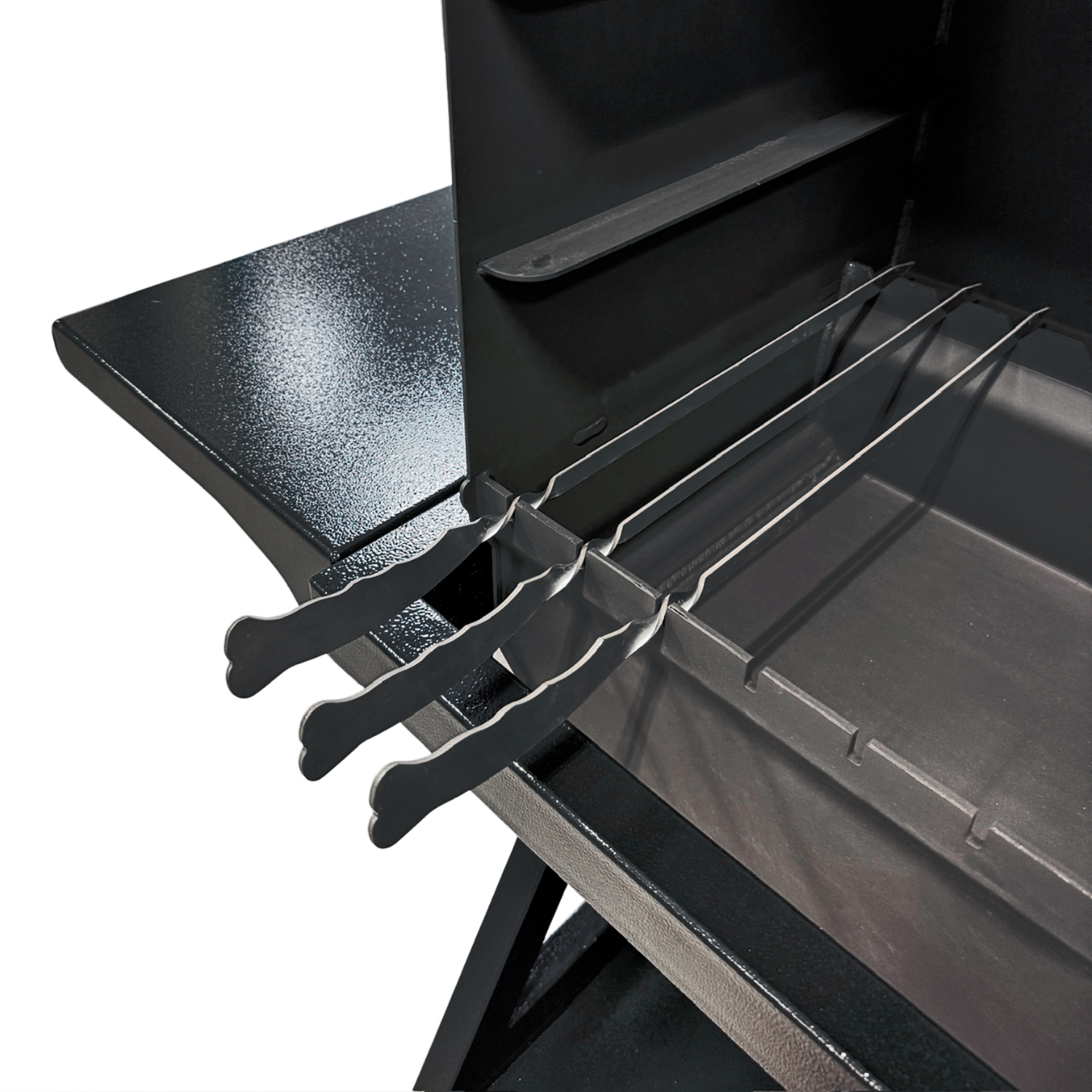 Drei Grillspieße auf einem schwarzen Grill mit einer seitlichen Ablage.