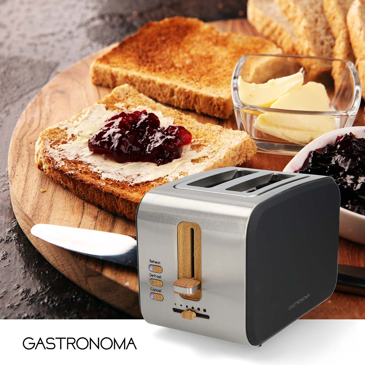 Een broodrooster met toast, boter en jam op een houten tafel.