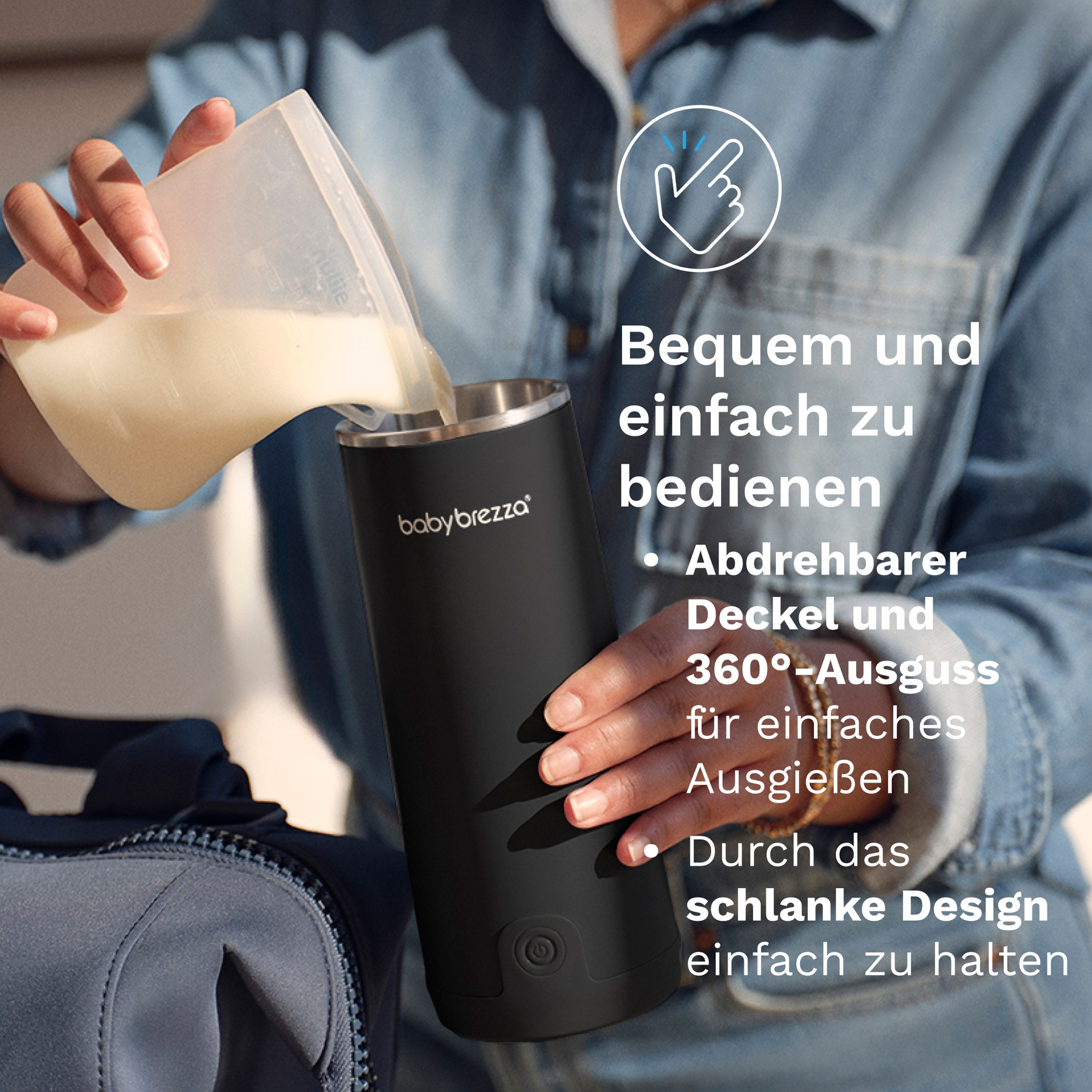 Eine Hand gießt Flüssigkeit aus einem Messbecher in einen schwarzen Babybrezza Behälter.