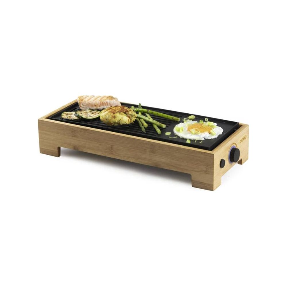 Elektrischer Grill mit Bambusrahmen, darauf Fisch, Gemüse, Spargel und Ei.