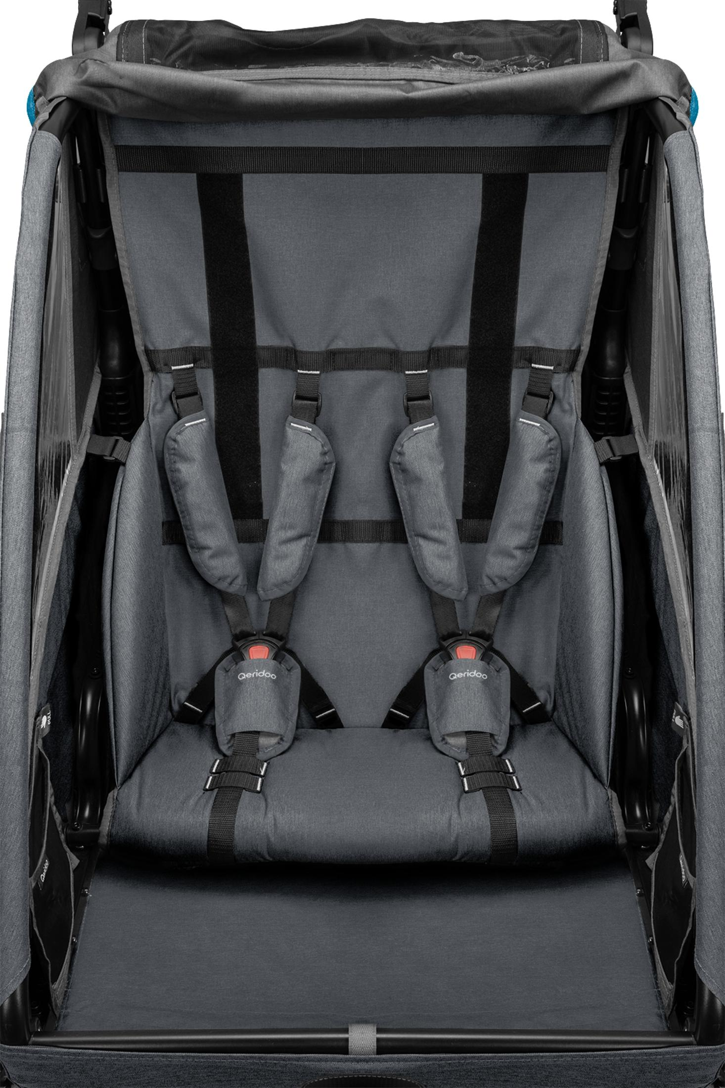 Grauer Kinderwagen mit Gurten und Polsterung. Sicherheitsschloss mit rotem Knopf.