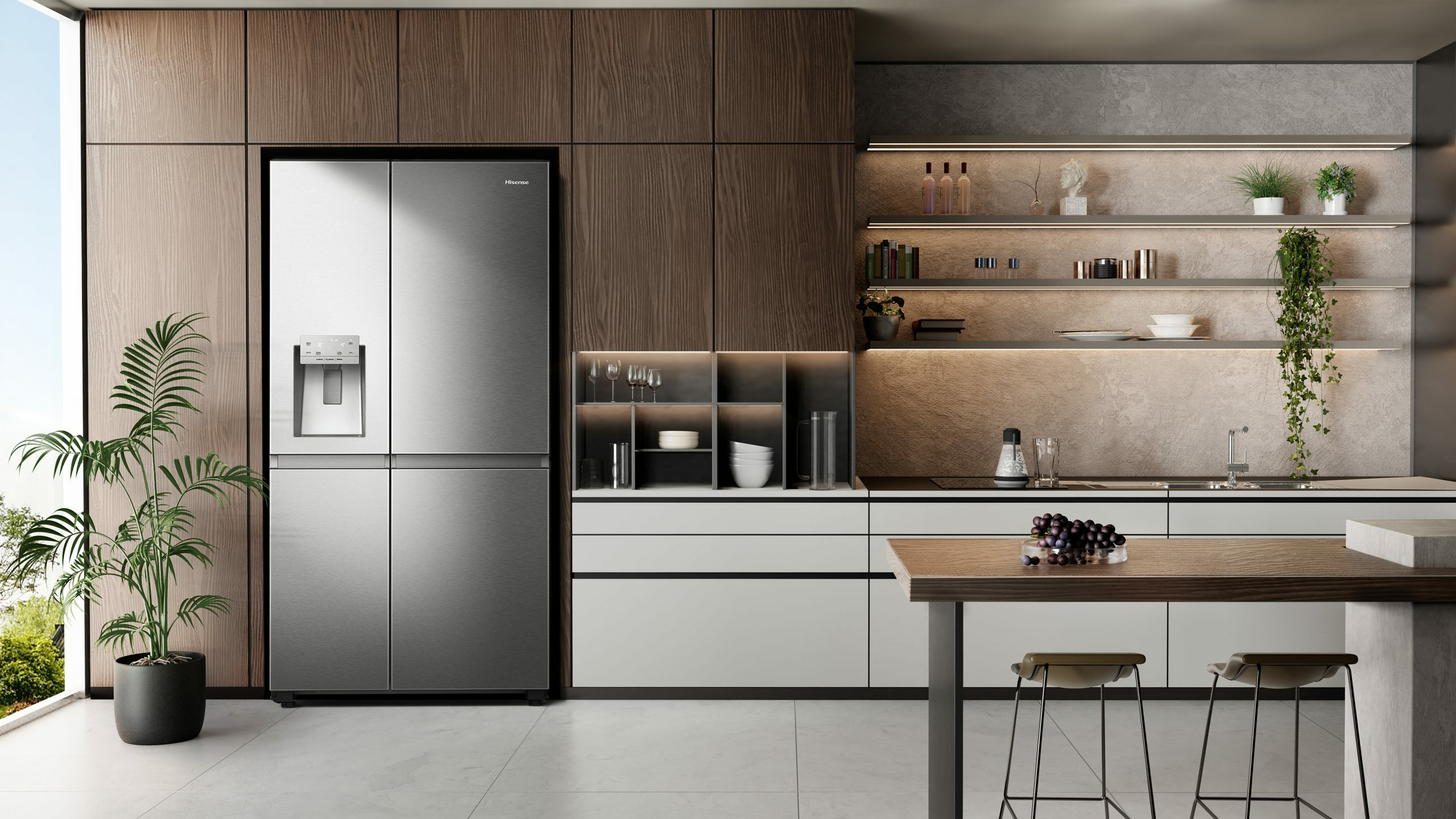 Cocina moderna con frigorífico de acero inoxidable, gabinetes de madera y mostrador con uvas.